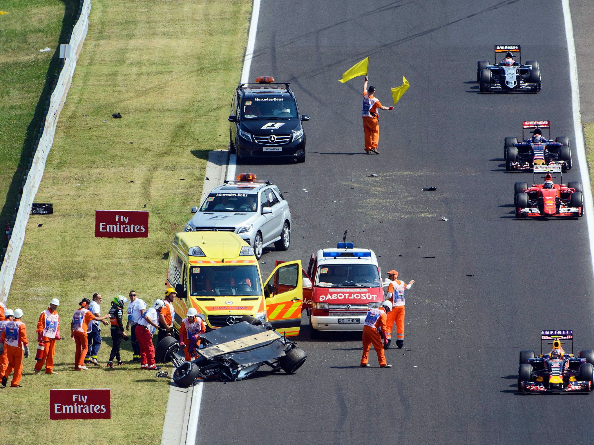 The rest of the field avoid the accident on their way back to the pits