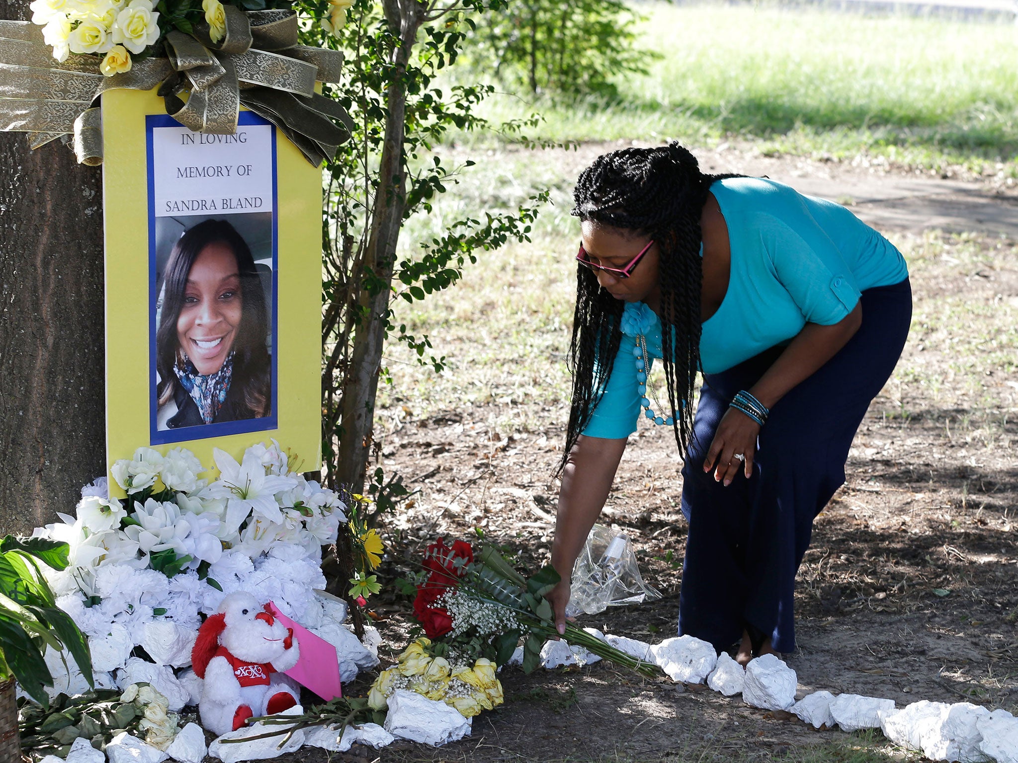 Jeanette Williams places a bouquet of roses at a memorial for Sandra Bland near Prairie View A&M University, Tuesday, July 21, 2015, in Prairie View, Texas