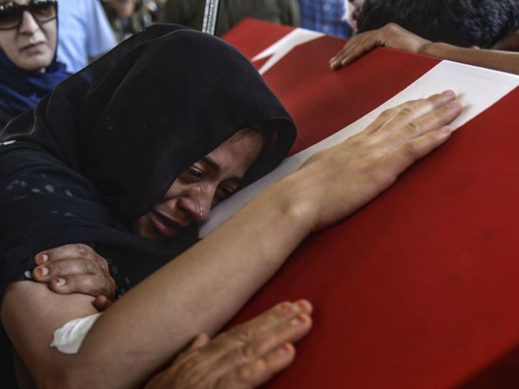 Wife of Turkish soldier Mehmet Yavuz Nane cries on her husband coffin during the burial ceremony on July 24, 2015