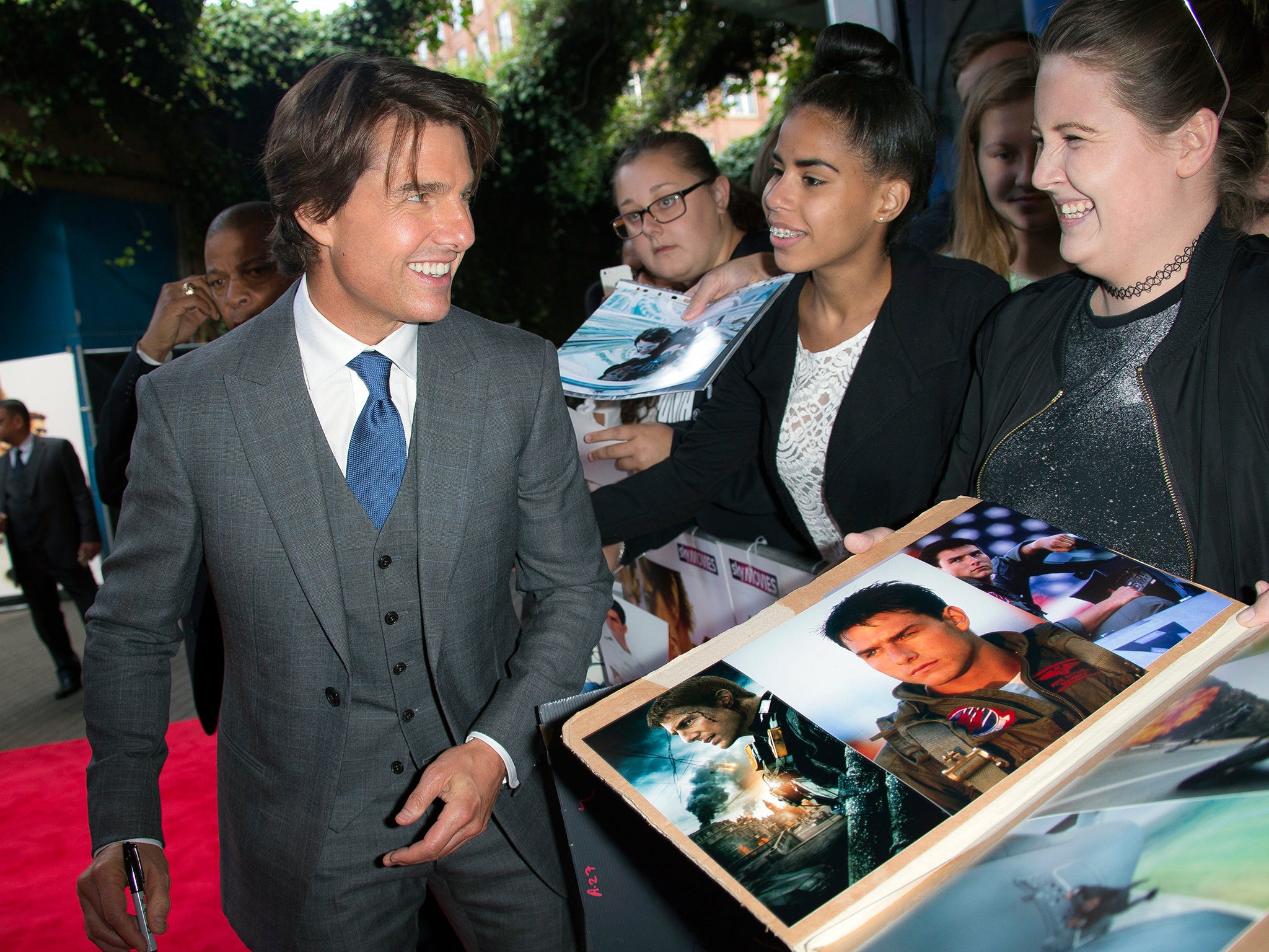 Actor Tom Cruise signs autographs for fans as he arrives for the UK premiere of Mission: Impossible- Rogue Nation