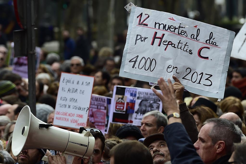 Hepatitis C sufferers hold placards during a demonstration at Spain's health ministry in December 2014, saying they are being denied access to a new drug that could cure them of the deadly liver disease