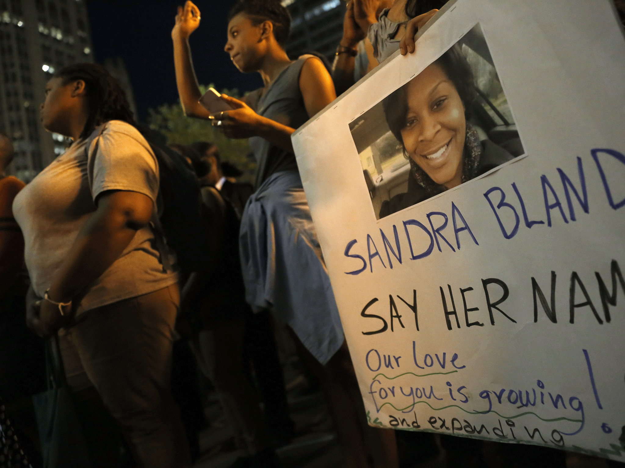 A demonstrator holds a Sandra Bland sign during a vigil on 28 July in Chicago