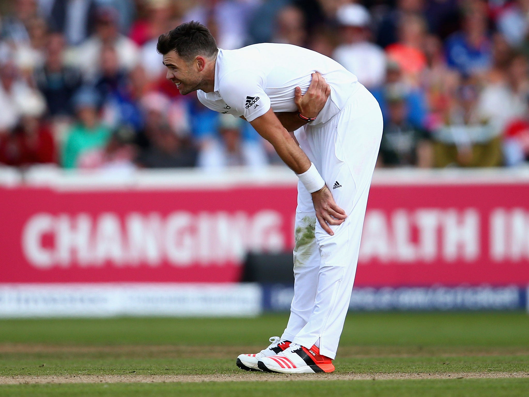 Jimmy Anderson grimaces in pain after suffering a side strain - he will be assessed by England medics