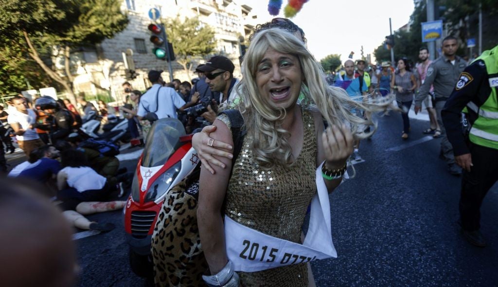 A parade participant cowers as an Orthodox extremist attacks pride parade participants