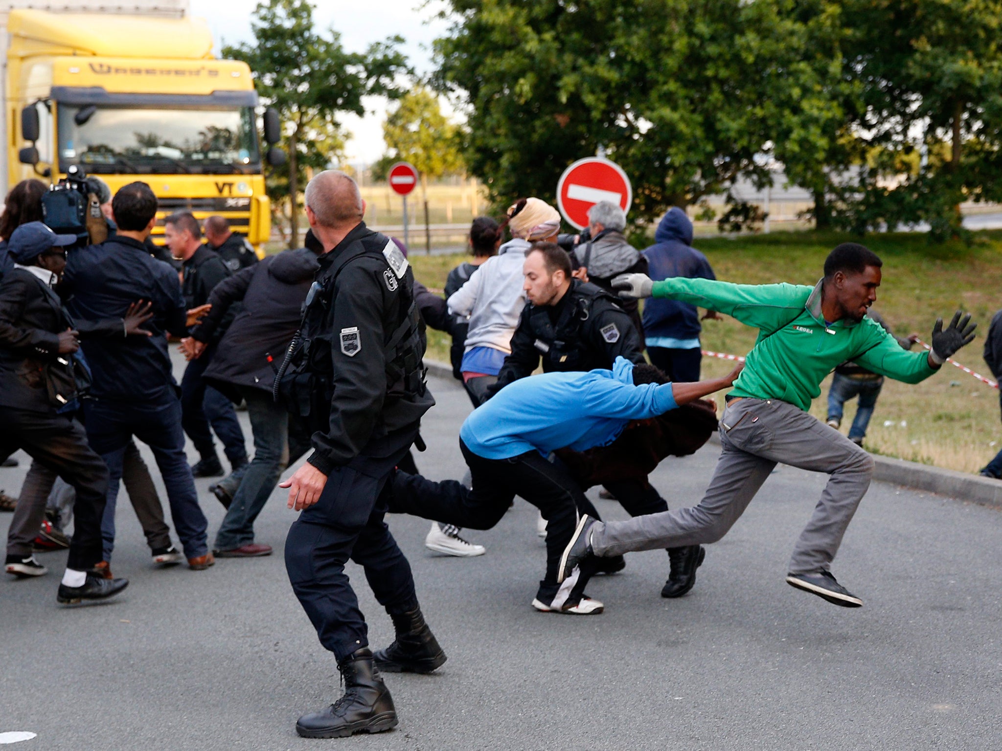 Migrants escape from the French Police as they try to catch a train to reach England