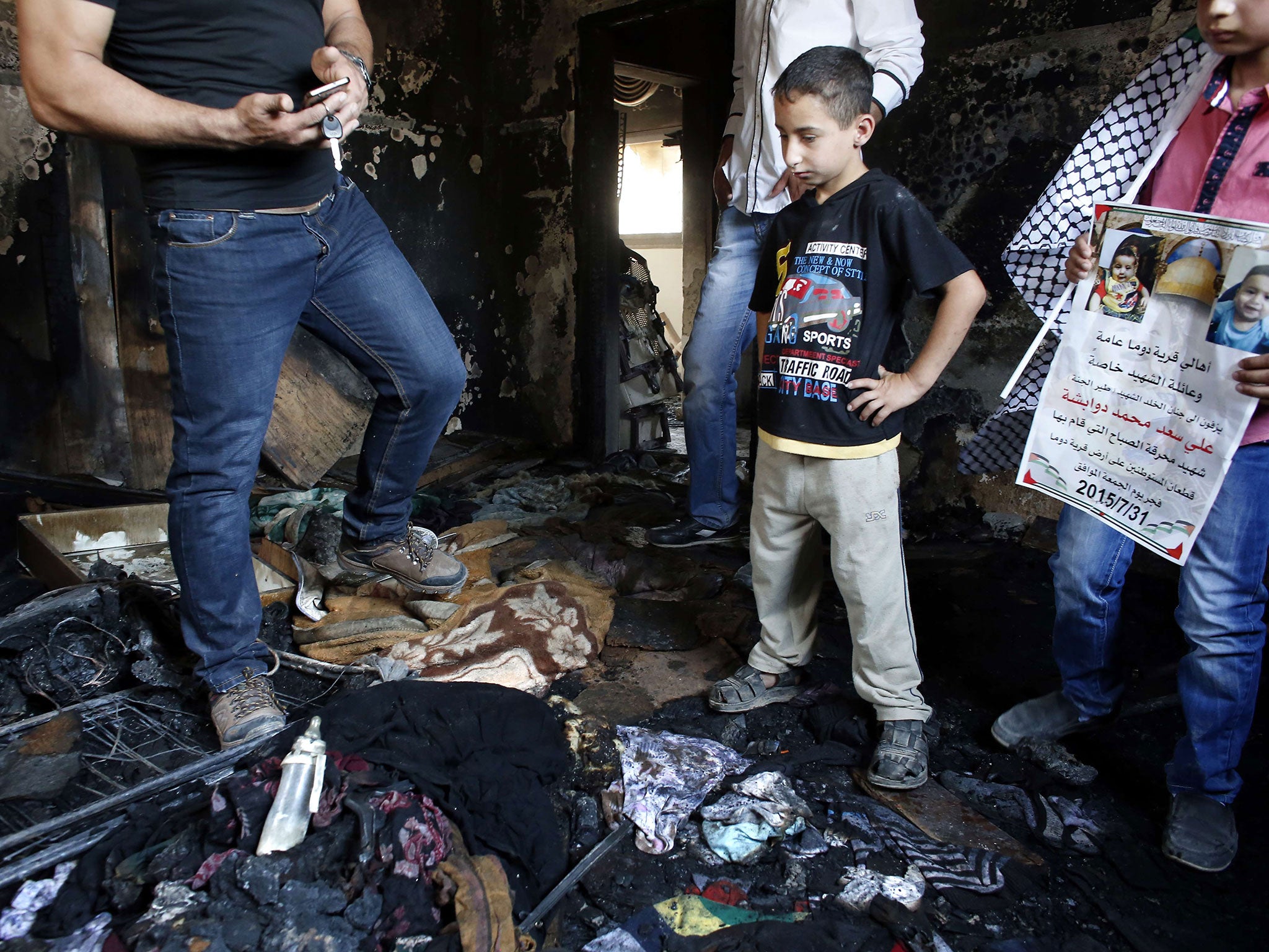 Palestinians look at the damage as they stand in a house set on fire by Jewish settlers and where 18-month-old Palestinian toddler Ali Saad Dawabsha died on 31 July, 2015