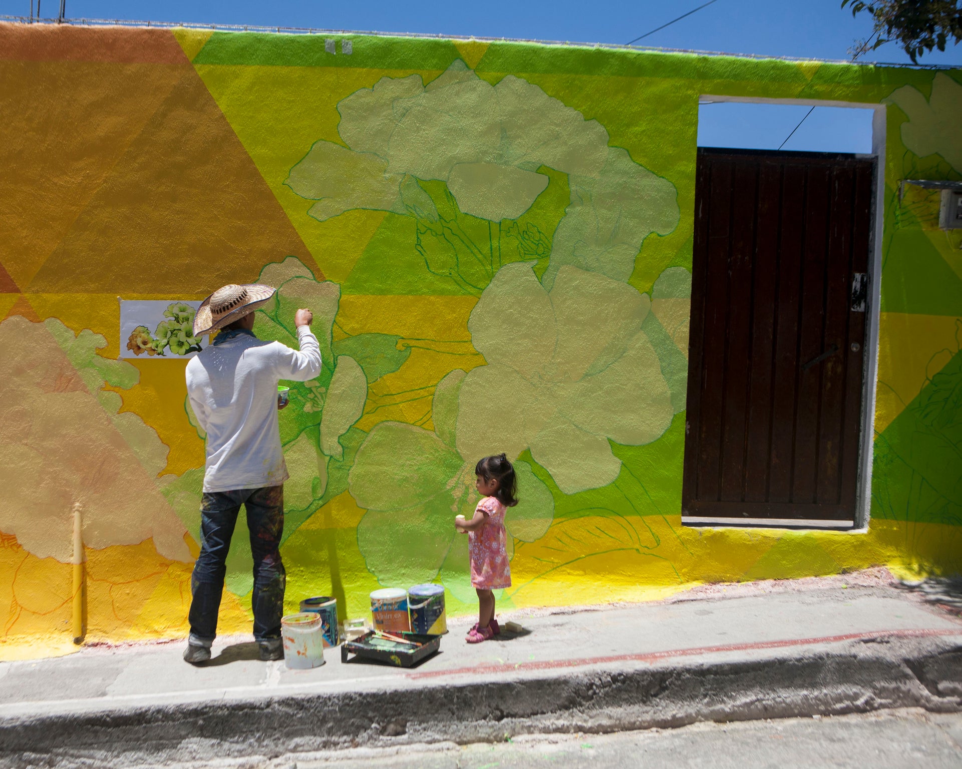 A man paints his home in Las Palmitas