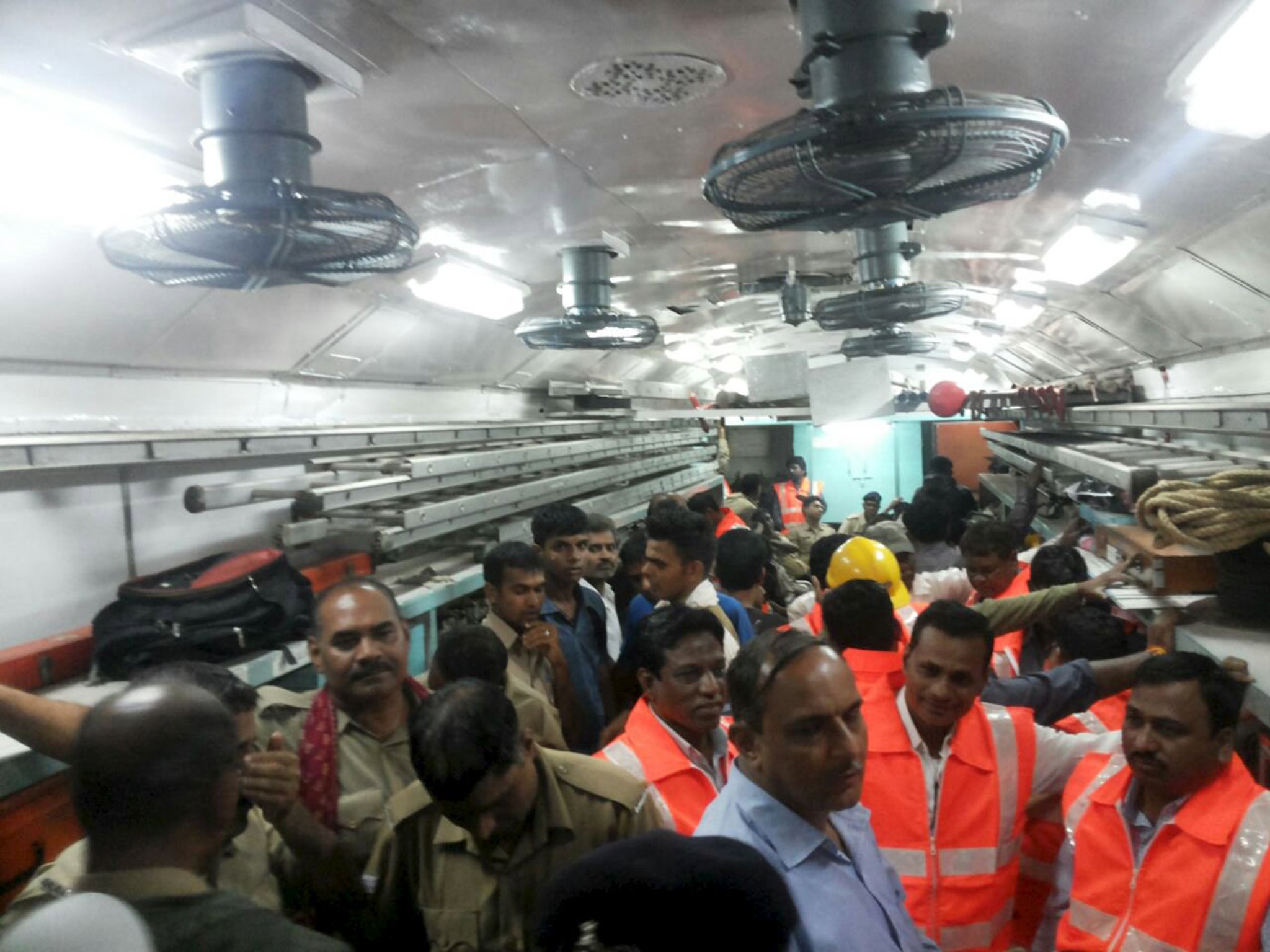 Officials and members of the rescue operation stand in a carriage of a derailed train near Harda, Madhya Pradesh