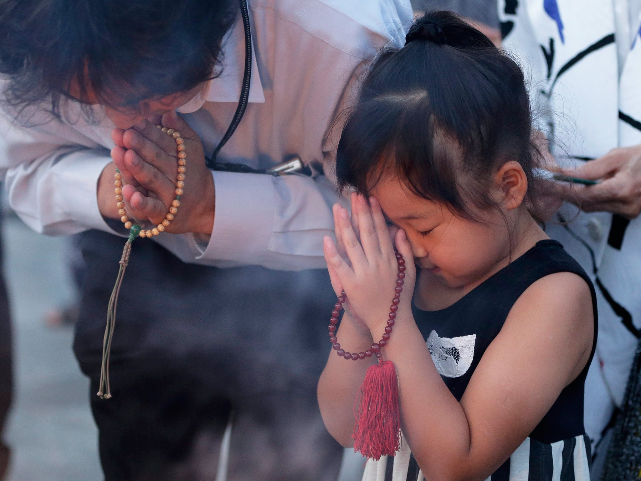 A girl offers a prayer for victims of the atomic bombing during World War II in 1945