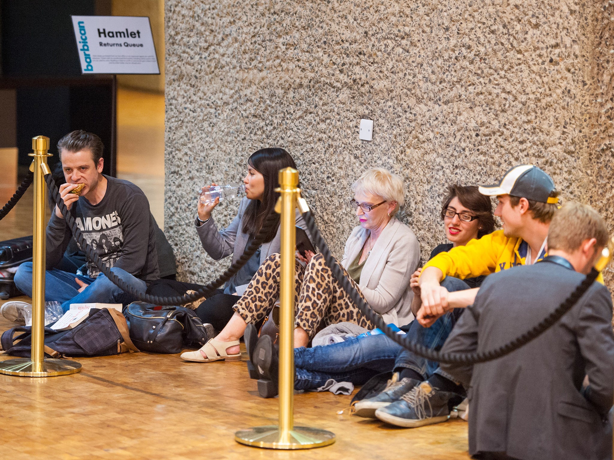 People queue for returned tickets for the opening night of 'Hamlet', starring Benedict Cumberbatch, which opens at the Barbican Centre in London