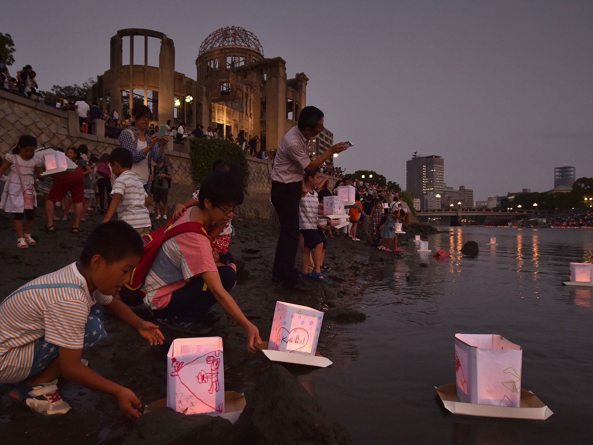 People release paper lanterns into the Motoyasu River in front of the Atomic Bomb Dome