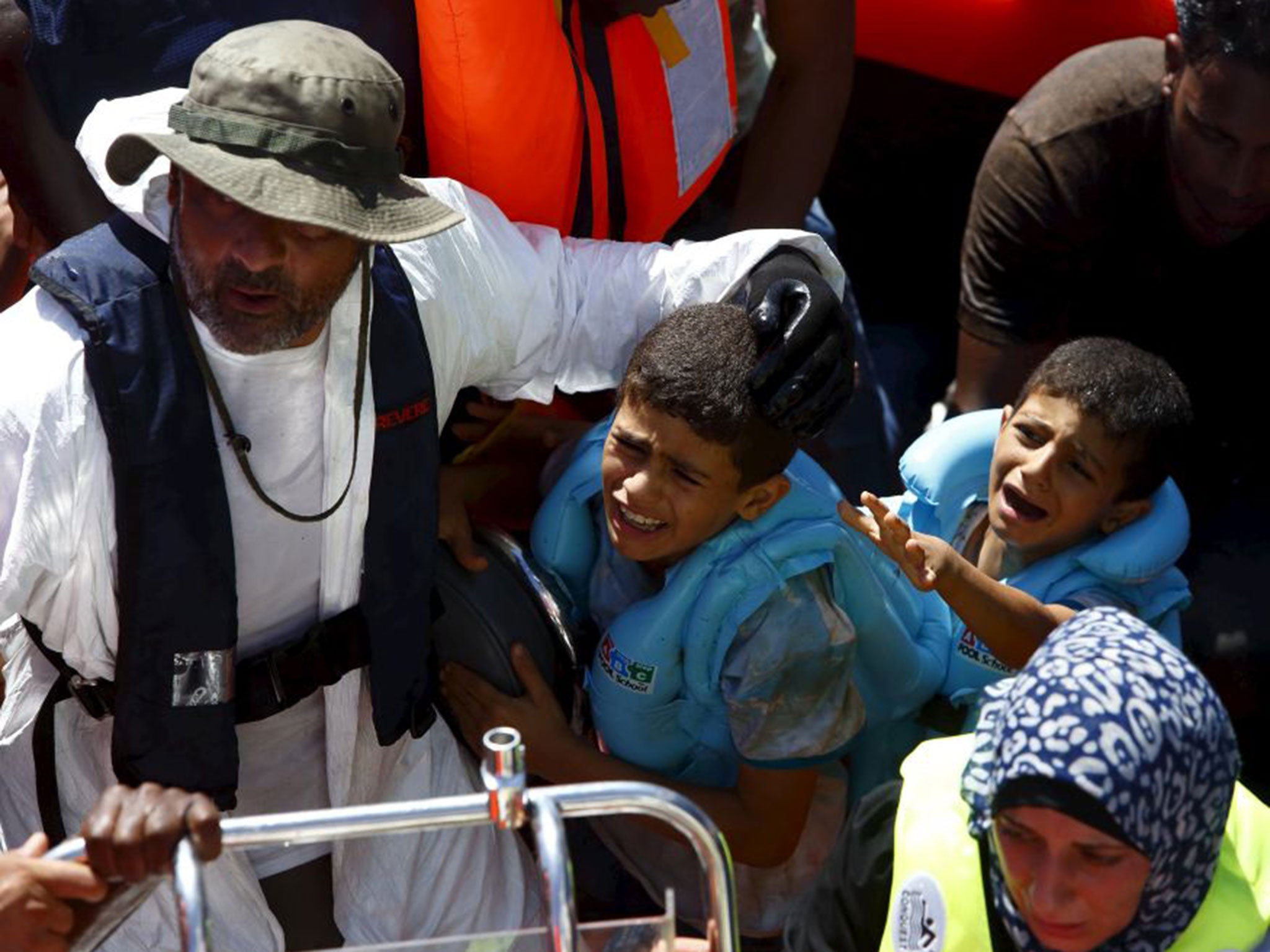 Migrant children cry as they arrive alongside the Migrant Offshore Aid Station (MOAS) ship MV Phoenix after being rescued from an overloaded wooden boat 10.5 miles (16 km) off the coast of Libya