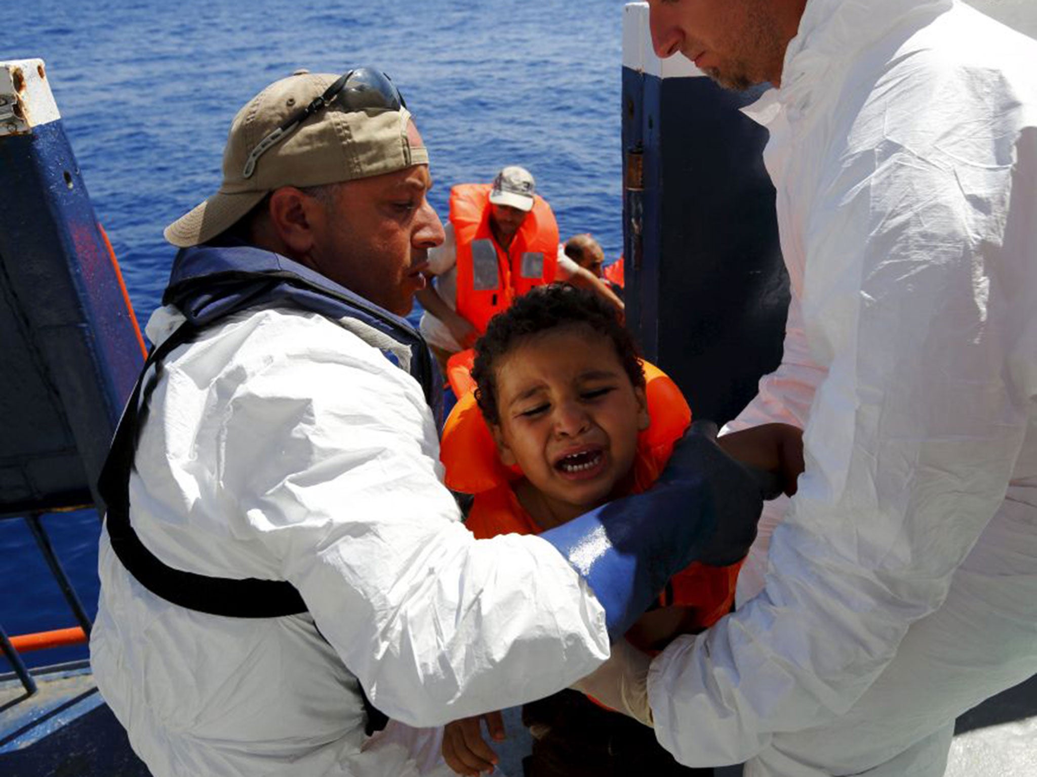 A migrant child being rescued from a capsized boat off the coast of Libya on Wednesday