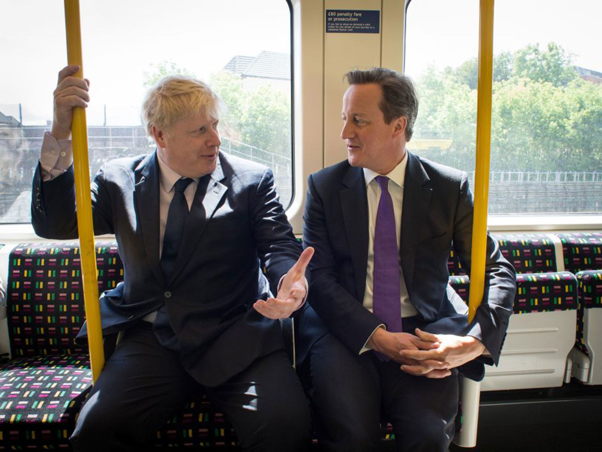 The Mayor of London Boris Johnson (L) and British Prime Minister David Cameron speak as they travel on an underground train to Westminster