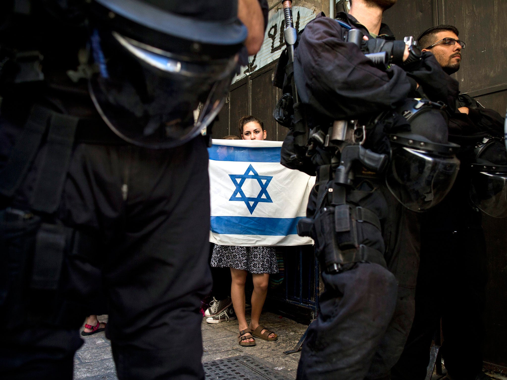 A right-wing Jewish girl holding an Israeli flag at the entrance to the al-Aqsa mosque in Jerusalem