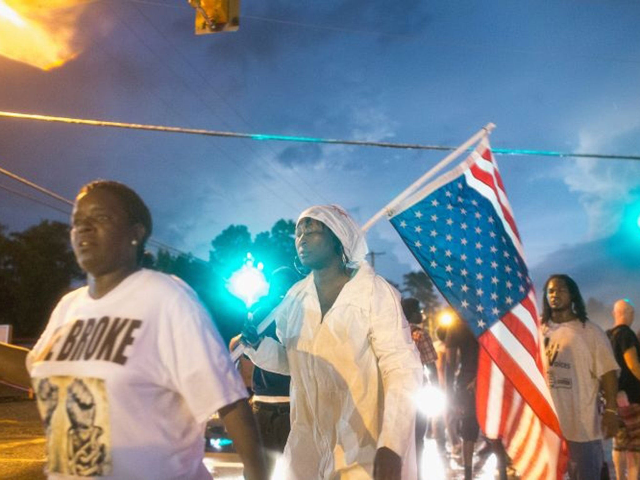 A woman waves an inverted US flag (Image: Scott Olson/Getty Images)