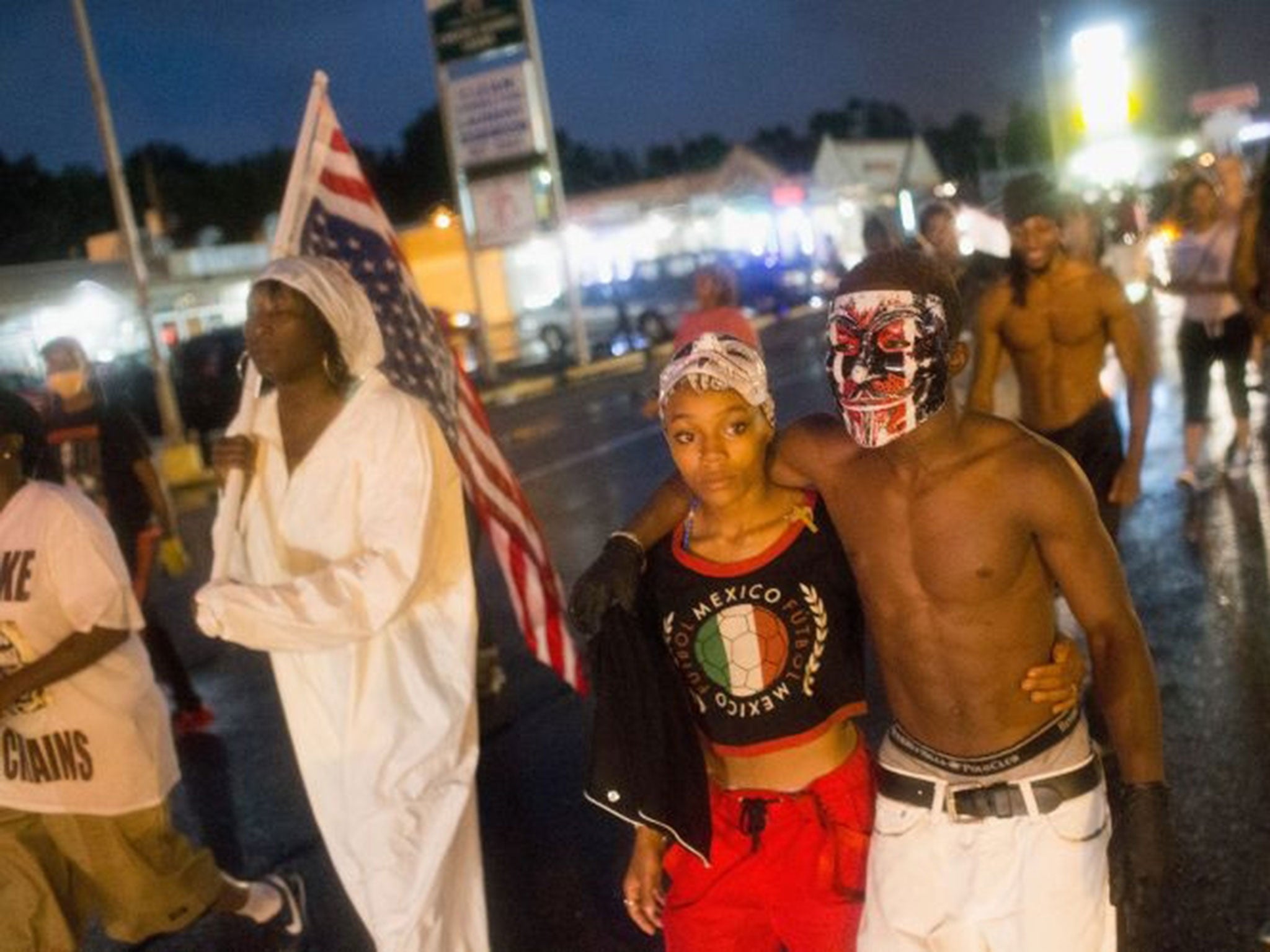 Demonstrators gather to mark the one-year anniversary of the shooting of Michael Brown