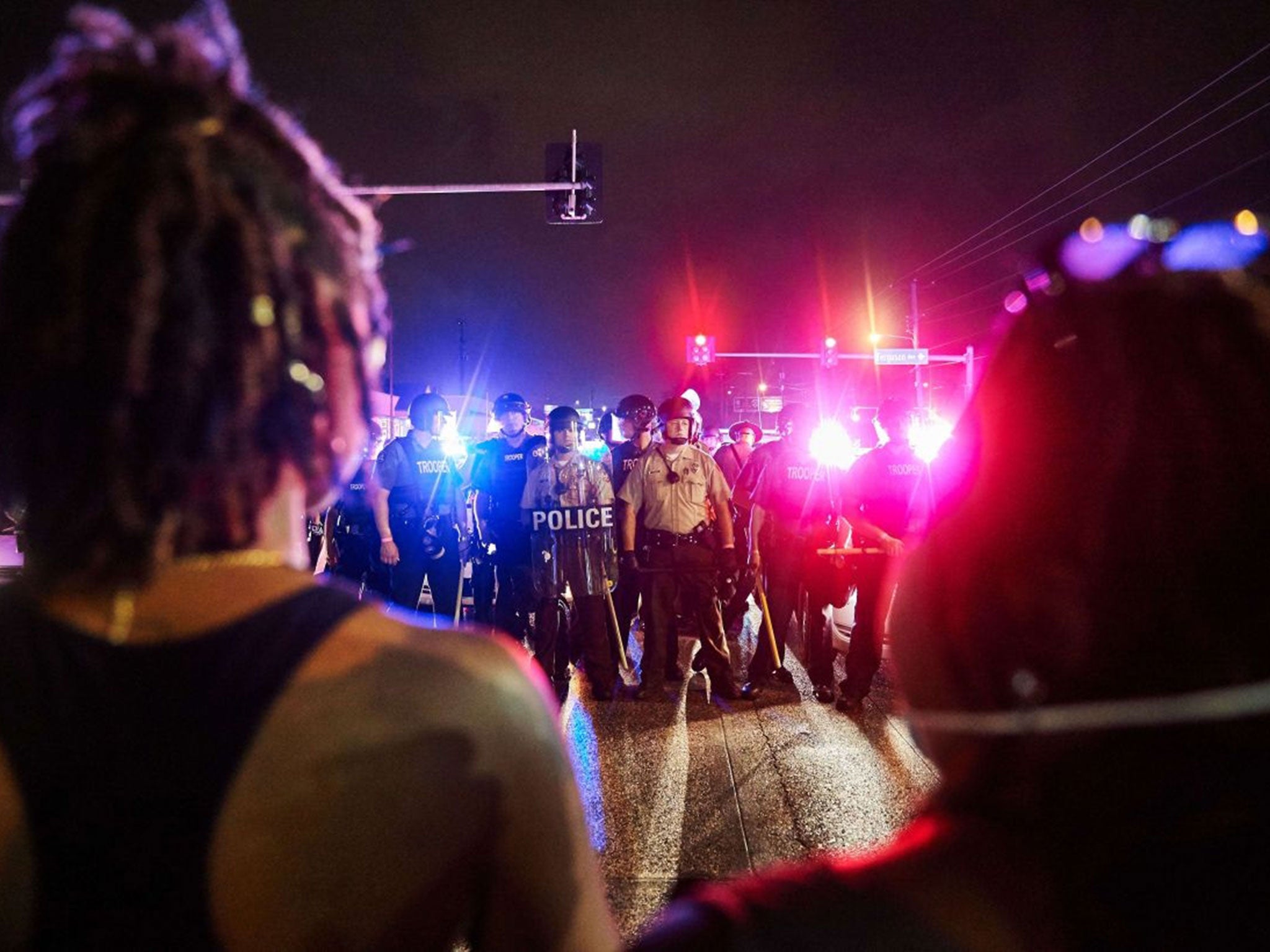 St. Louis County Police and Missouri State Highway Patrol troopers stand guard as protesters march on West Florissant Avenue (Image: Thomas/AFP/Getty Images)