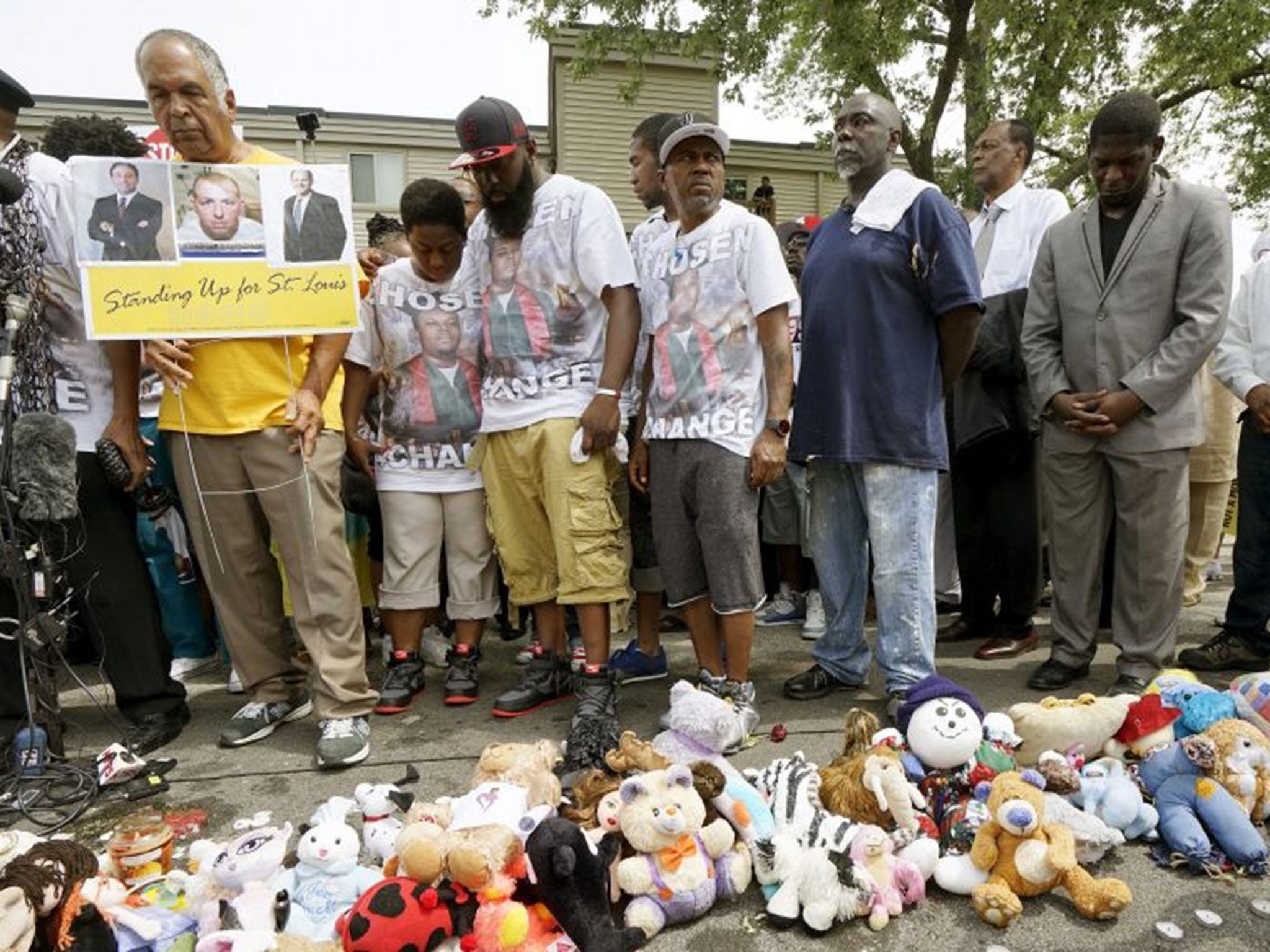 Michael Brown Sr., (centre) hugs his wife Cal Brown as they mark four-and-a-half minutes of silence for their son (Image: Rick Wilking/Reuters)