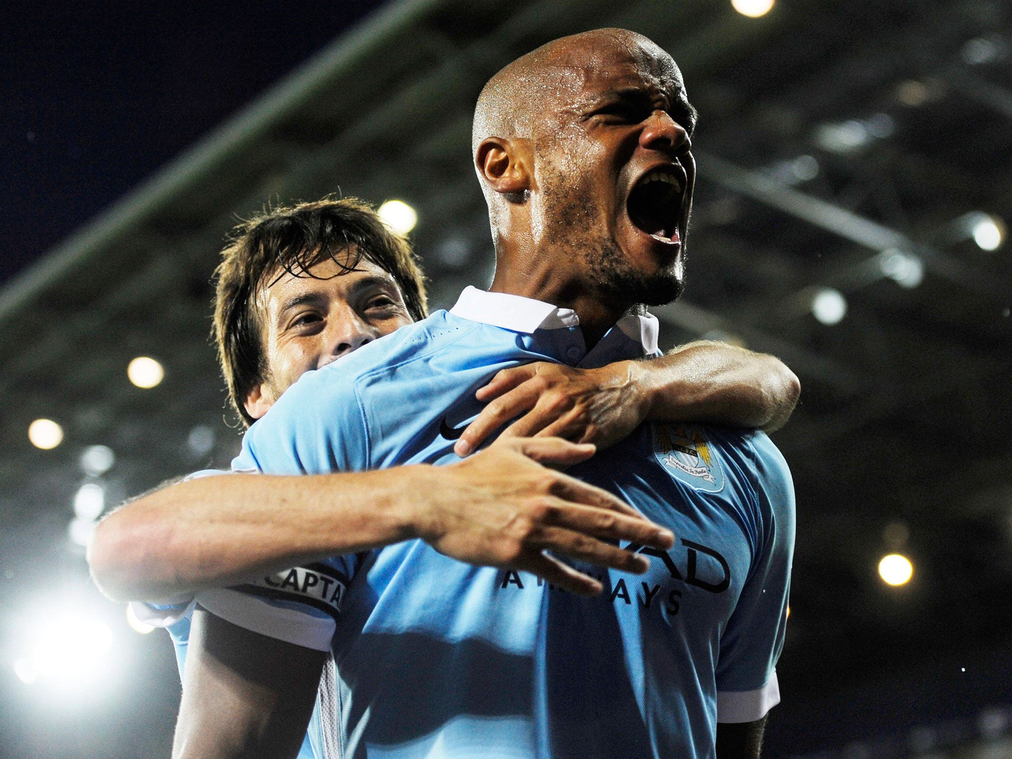 Manchester City's Vincent Kompany, right, celebrates with teammate David Silva after scoring