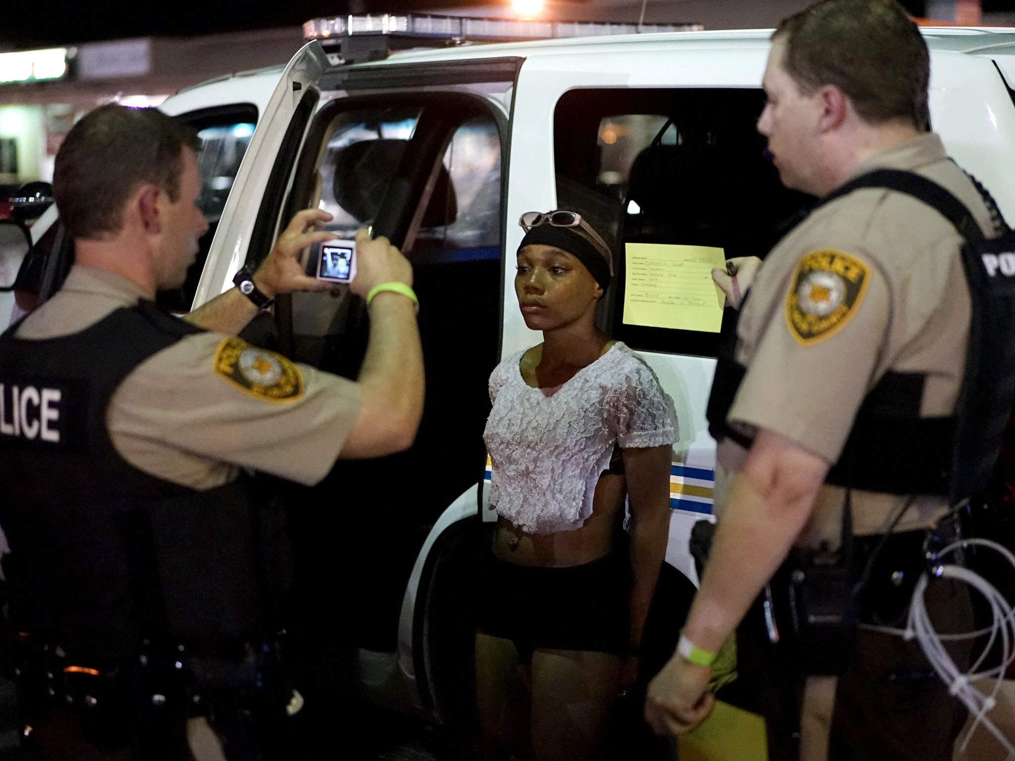 Police take a mug shot of a protester who was detained in Ferguson, Missouri, August 10, 2015.