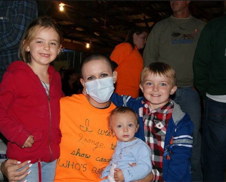 A photo posted to Facebook in 2013 showing Ms Weaver-Gates with a shaved head and a t-shirt saying 'I wear orange to show cancer who's boss'