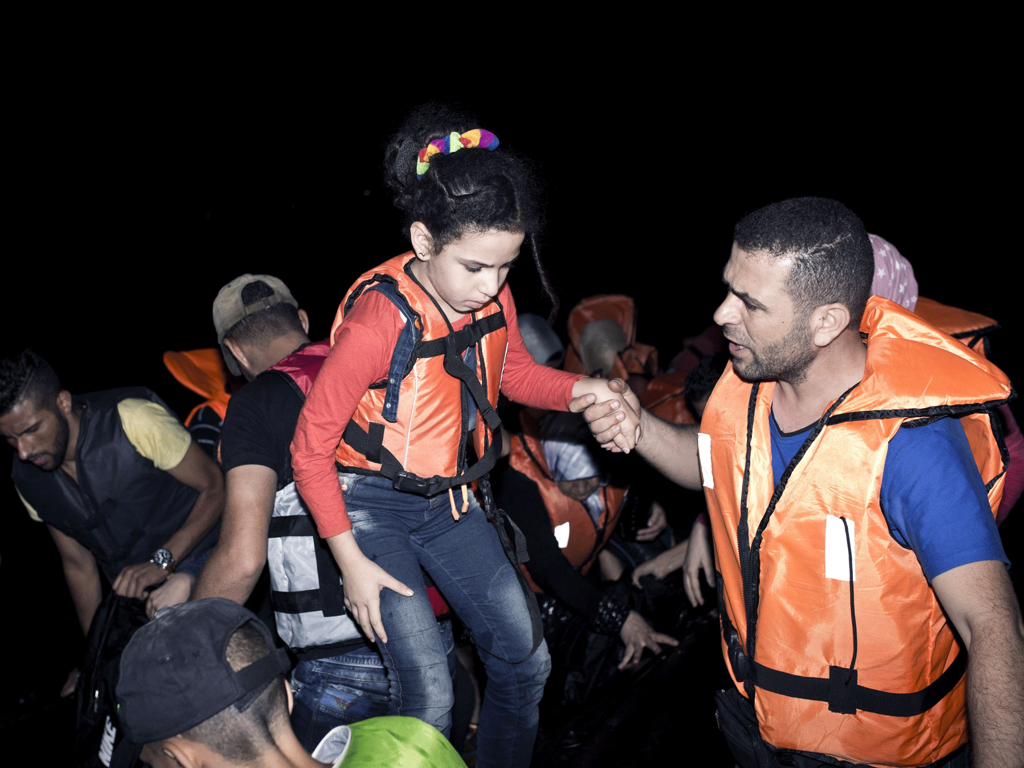 A young girl gets out of an inflatable boat as migrants arrive on a beach on Kos (AFP PHOTO / ANGELOS TZORTZINIS)