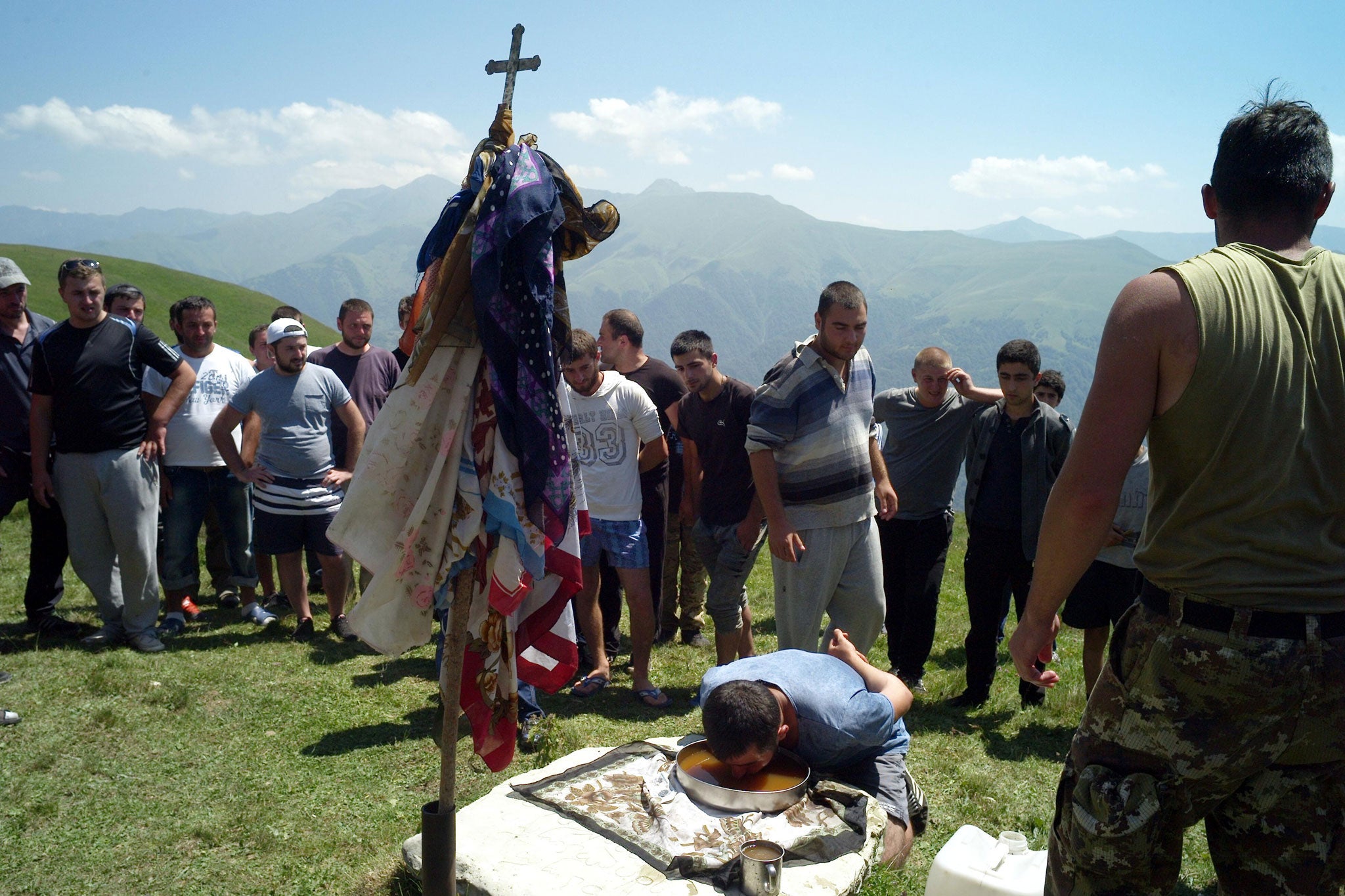 A villager tackles a vessel of holy beer. Drinking and toasting are all part of the ceremony