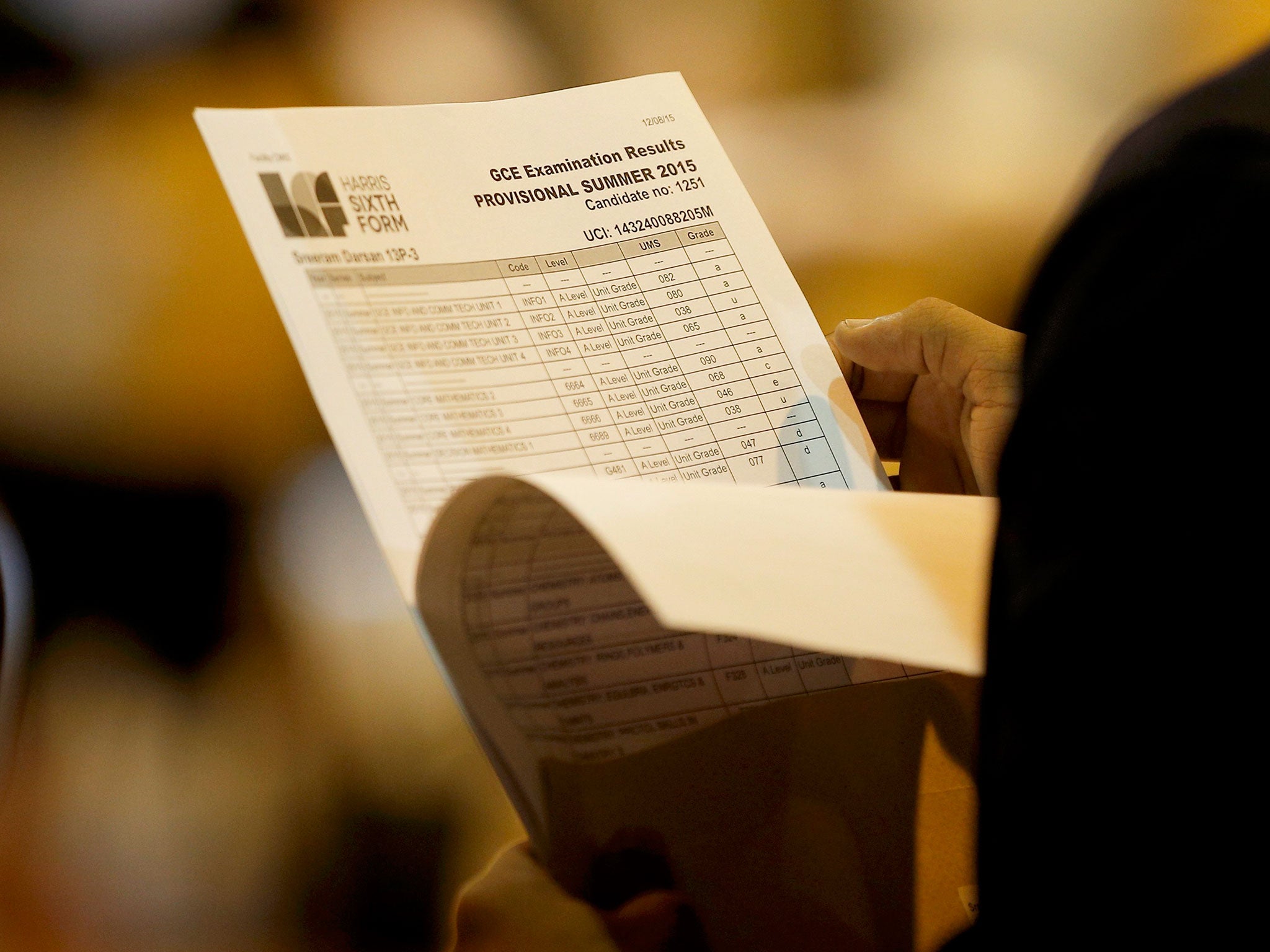 A student reads his A-level exam results at the Harris City Academy in London