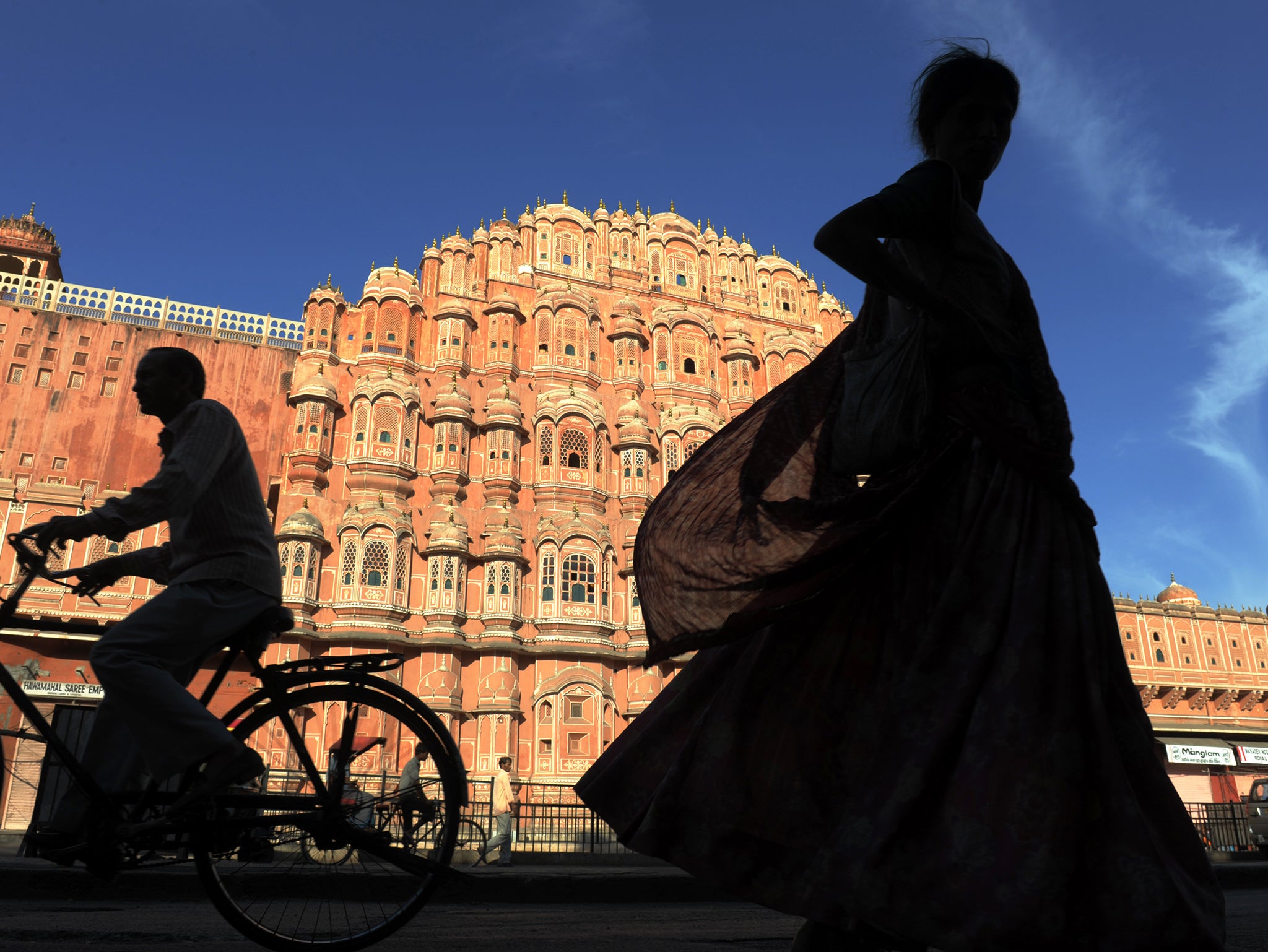 Residents of file past the Hawa Mahal, "Palace of Winds", in the old walled city of Jaipur