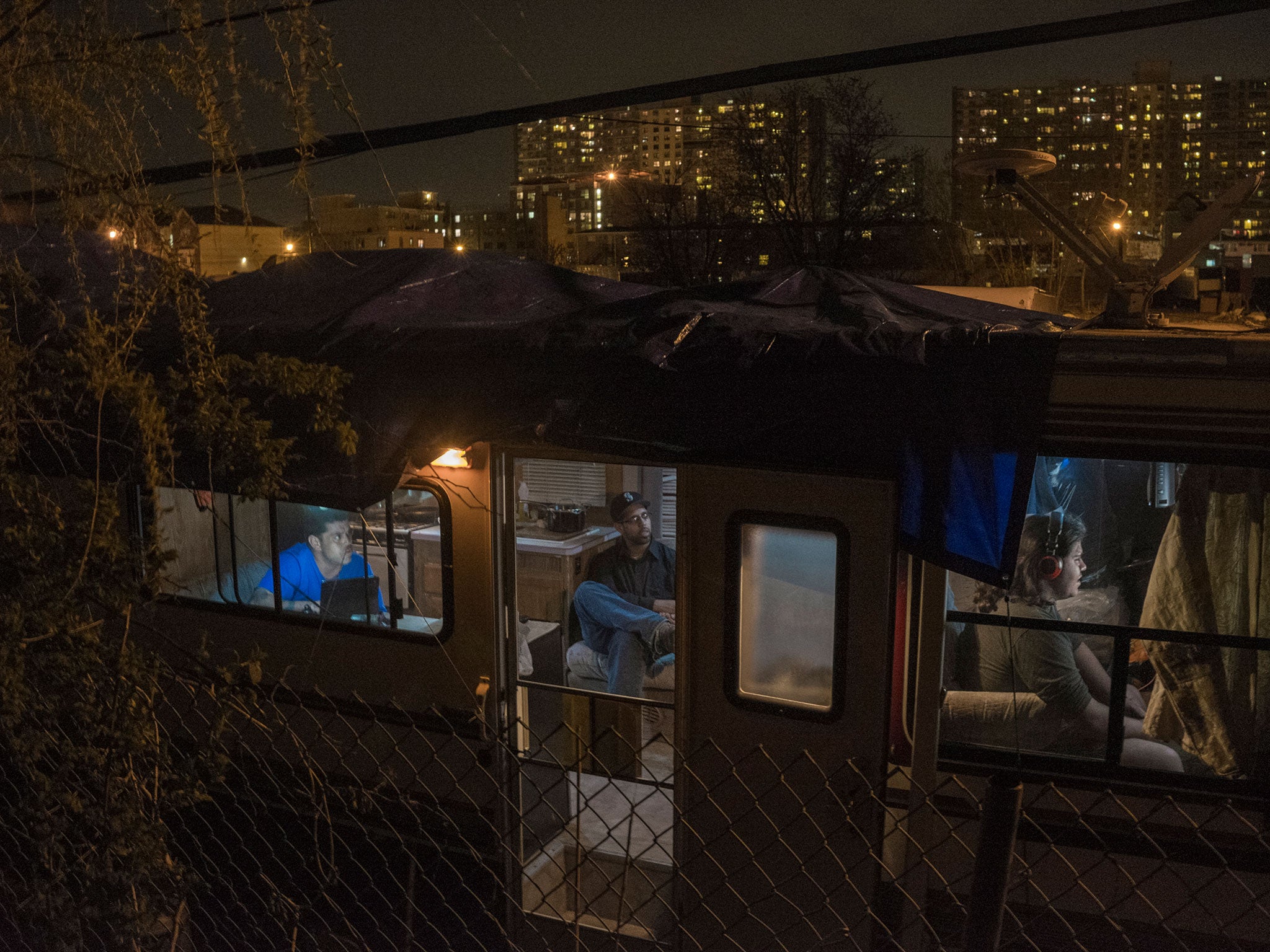 Men behaving sadly: in this picture from Allen Agostino’s exhibition, Hole residents Bam, Josh and Carlos watch TV in their trailer (© Allen Agostino)