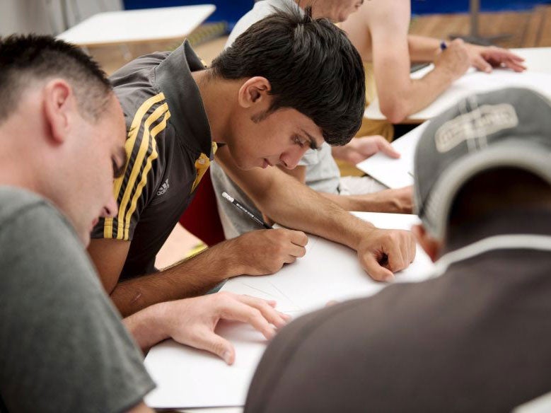 Migrants at a German lesson in an emergency shelter in Berlin on 13 August