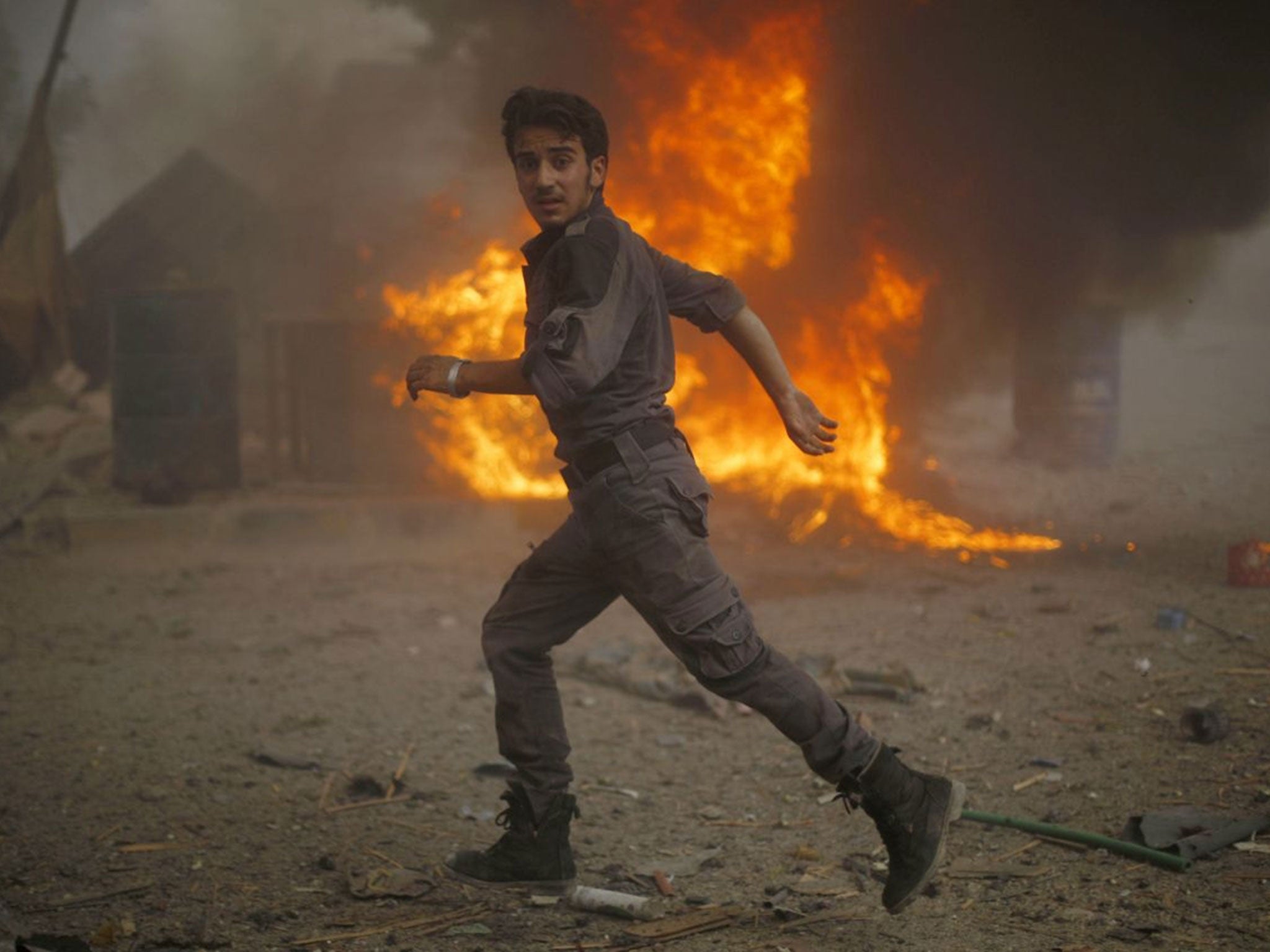 A Syrian emergency personnel runs towards a site of air strikes (Image: AFP)