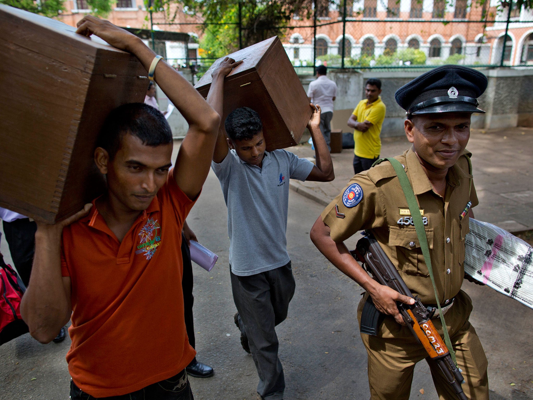 An armed policeman guards election workers