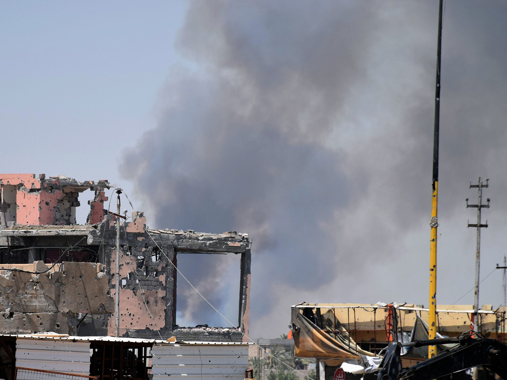 Smoke rises above a damaged building following a U.S.-led coalition airstrike against Islamic State group positions during a military operation to regain control of the eastern suburbs of Ramadi, in Anbar province, Iraq