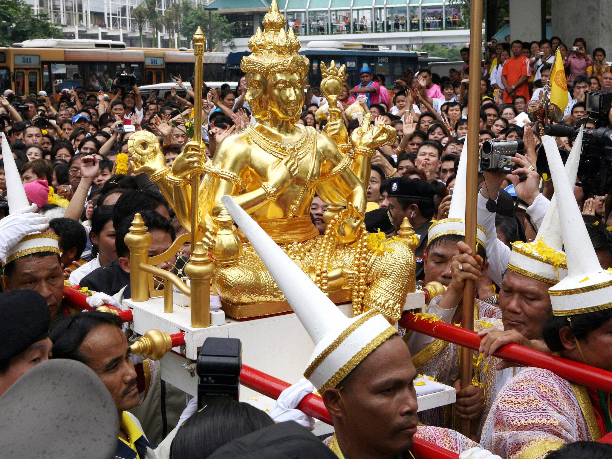 Devotees carry the Brahma statue during the shrine's reinstallation ceremony