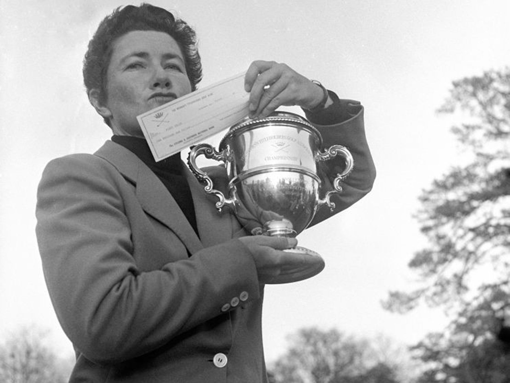 Suggs with the winner's trophy and cheque after a tournament in 1959: her manner was blunt, her speech salty