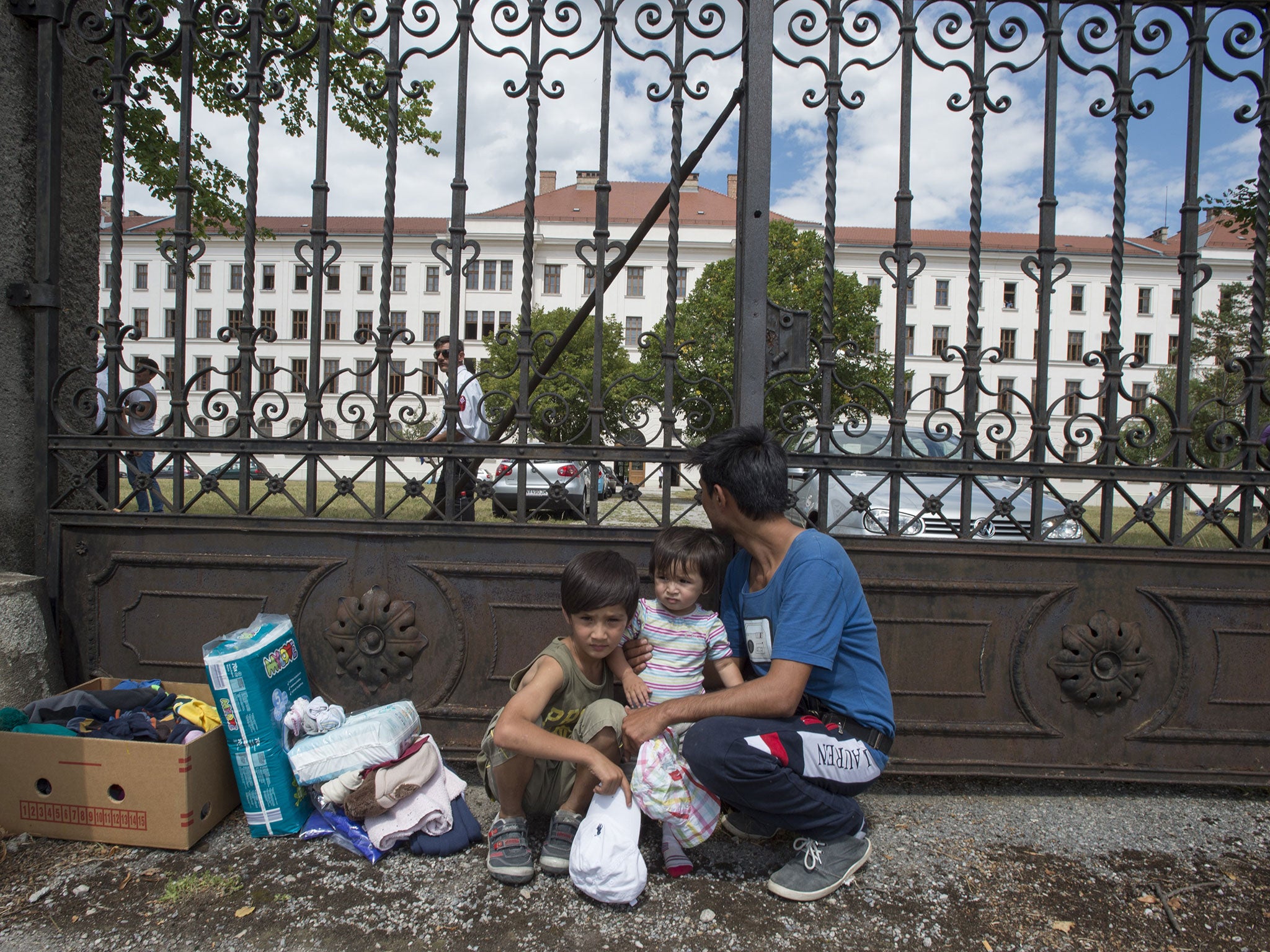 A father and his children wait outside Austria’s main refugee processing centre in Traiskirchen