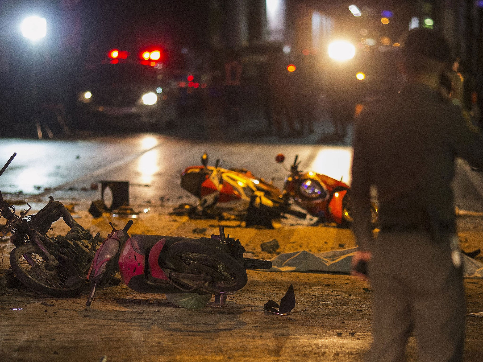 Debris and overturned motorcycles are strewn across the intersection across from the Erawan Shrine after an explosion in Bangkok