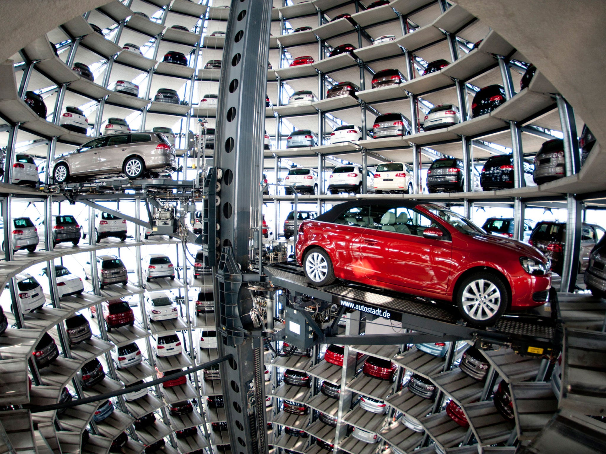 A VW Passat, left, and a Golf Cabrio car wait in the storage building of the Volkswagen company in Wolfsburg, Germany