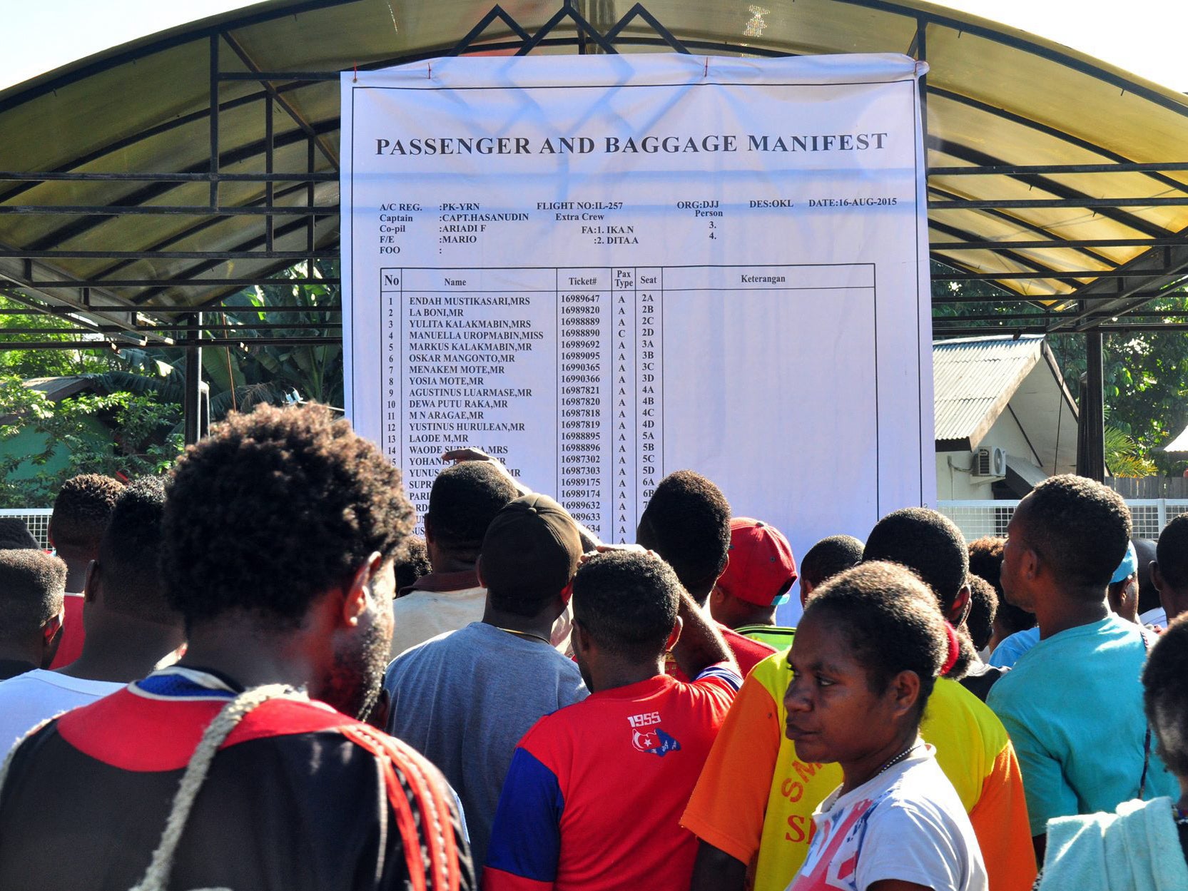 Relatives of passengers onboard the Trigana Air plane read the passenger manifest
