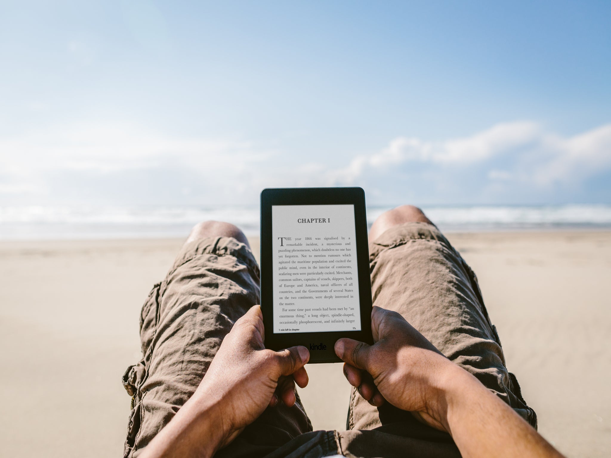 An Amazon Kindle being read on the beach