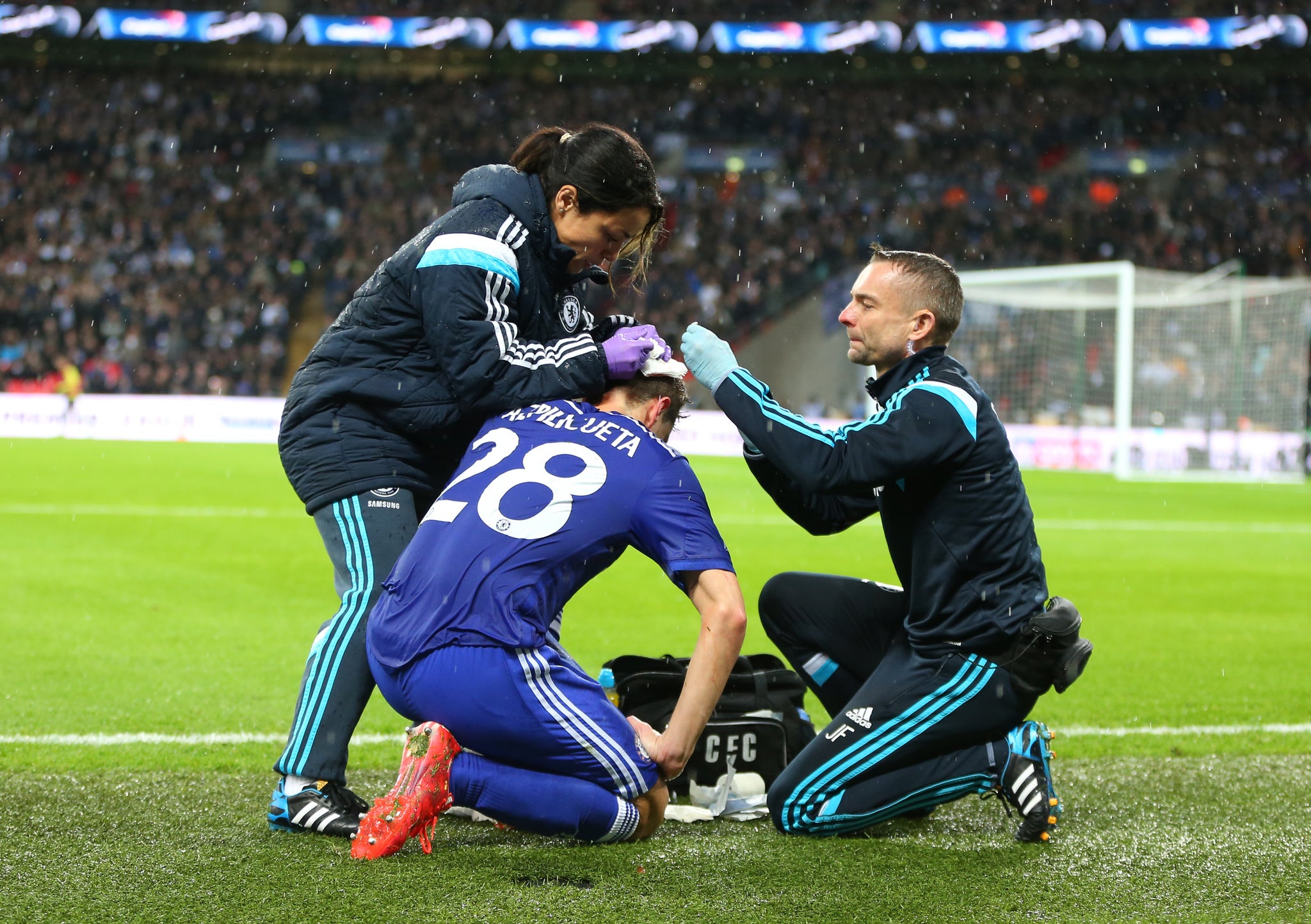 Cesar Azpilicueta of Chelsea is treated for a cut head by Dr Eva Carneiro