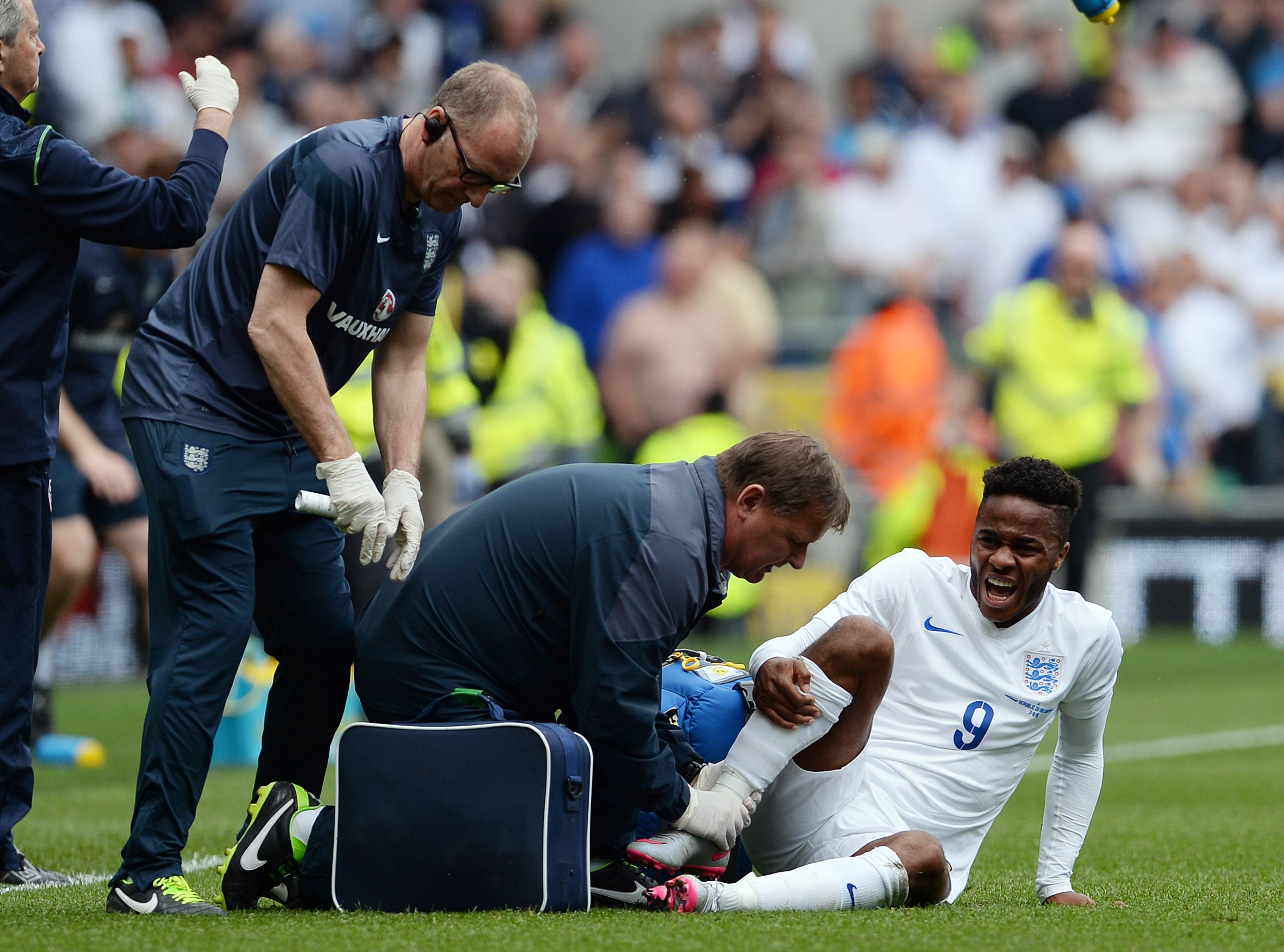 England physio Gary Lewin gives treatment to Raheem Sterling of England after an ankle injury