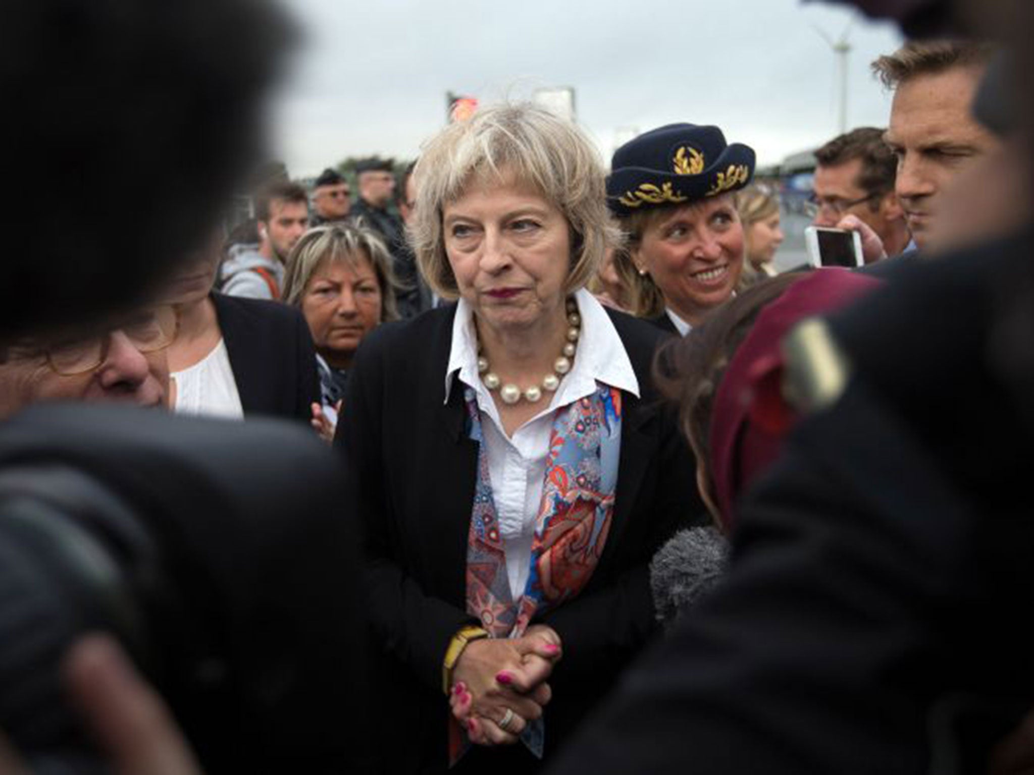 Theresa May is surrounded by journalists as she leaves after speaking to the media at the with French Interior Minister Bernard Cazeneuve