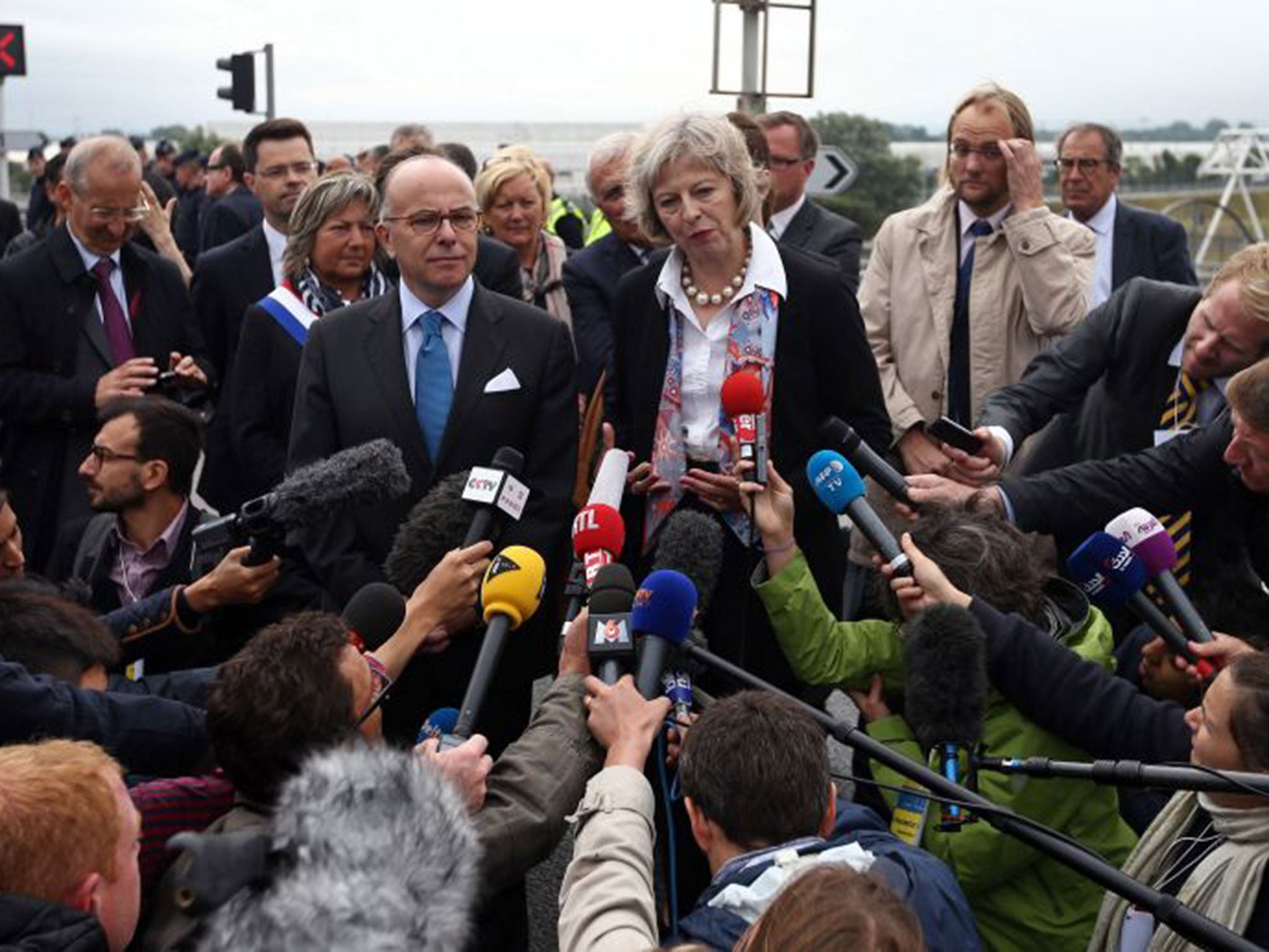 French Interior Minister Bernard Cazeneuve and Britain's Home Secretary Theresa May address the media at the Eurotunnel Terminal on August 20, 2015