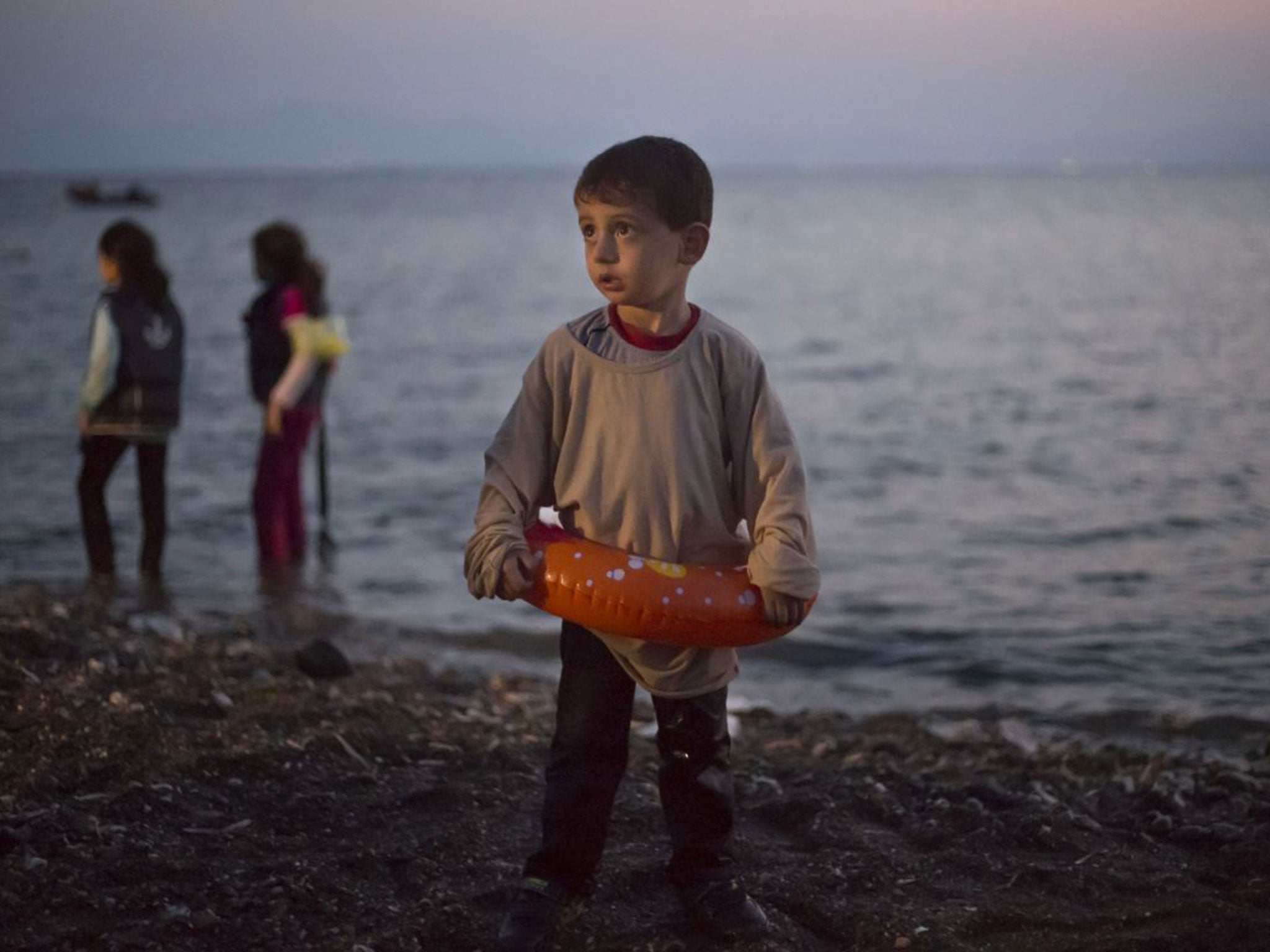 A Syrian migrant boy stands on the beach on the Greek island of Kos