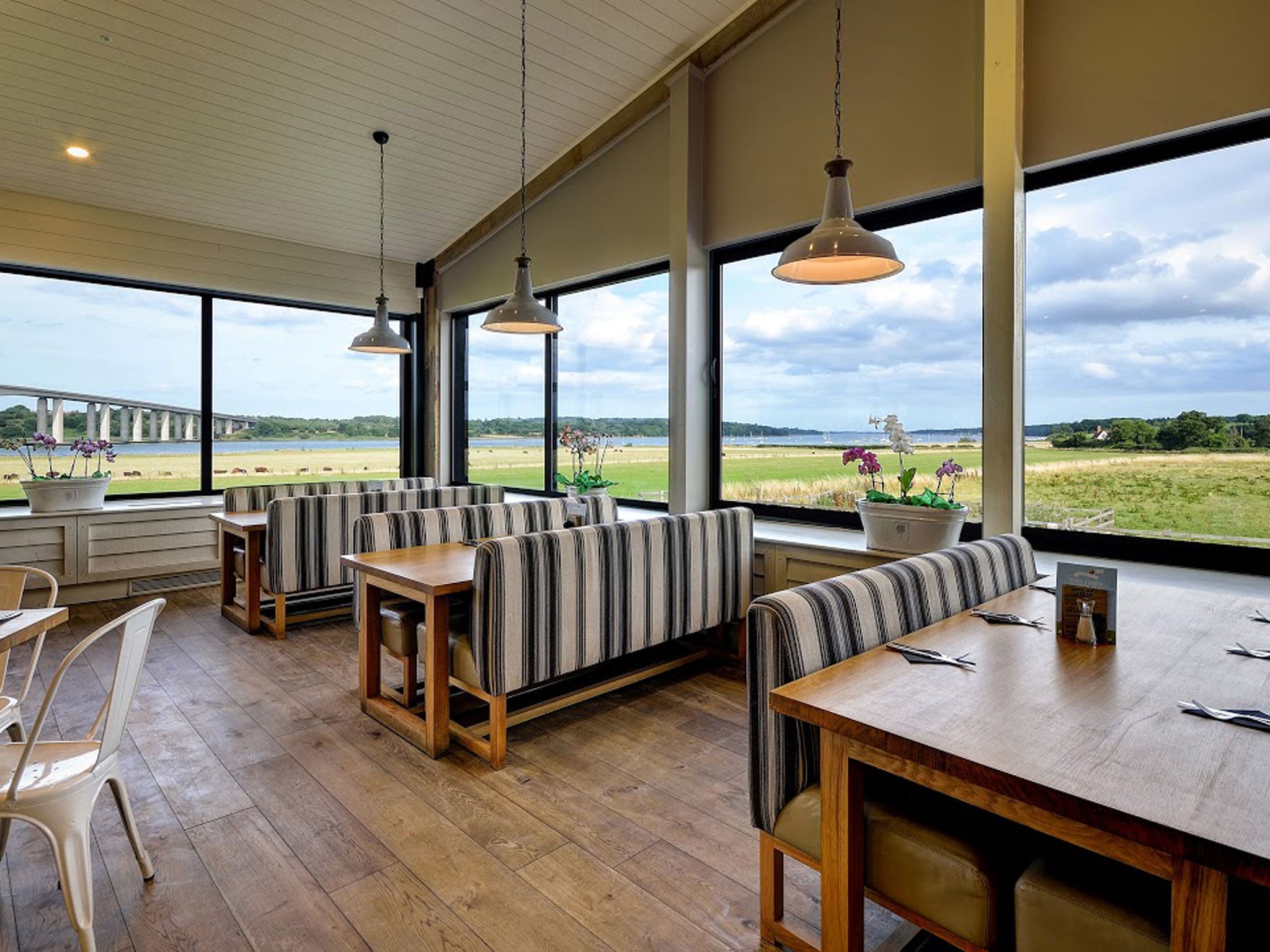 Diners eat lunch in a vast shop which overlooks a vast bridge