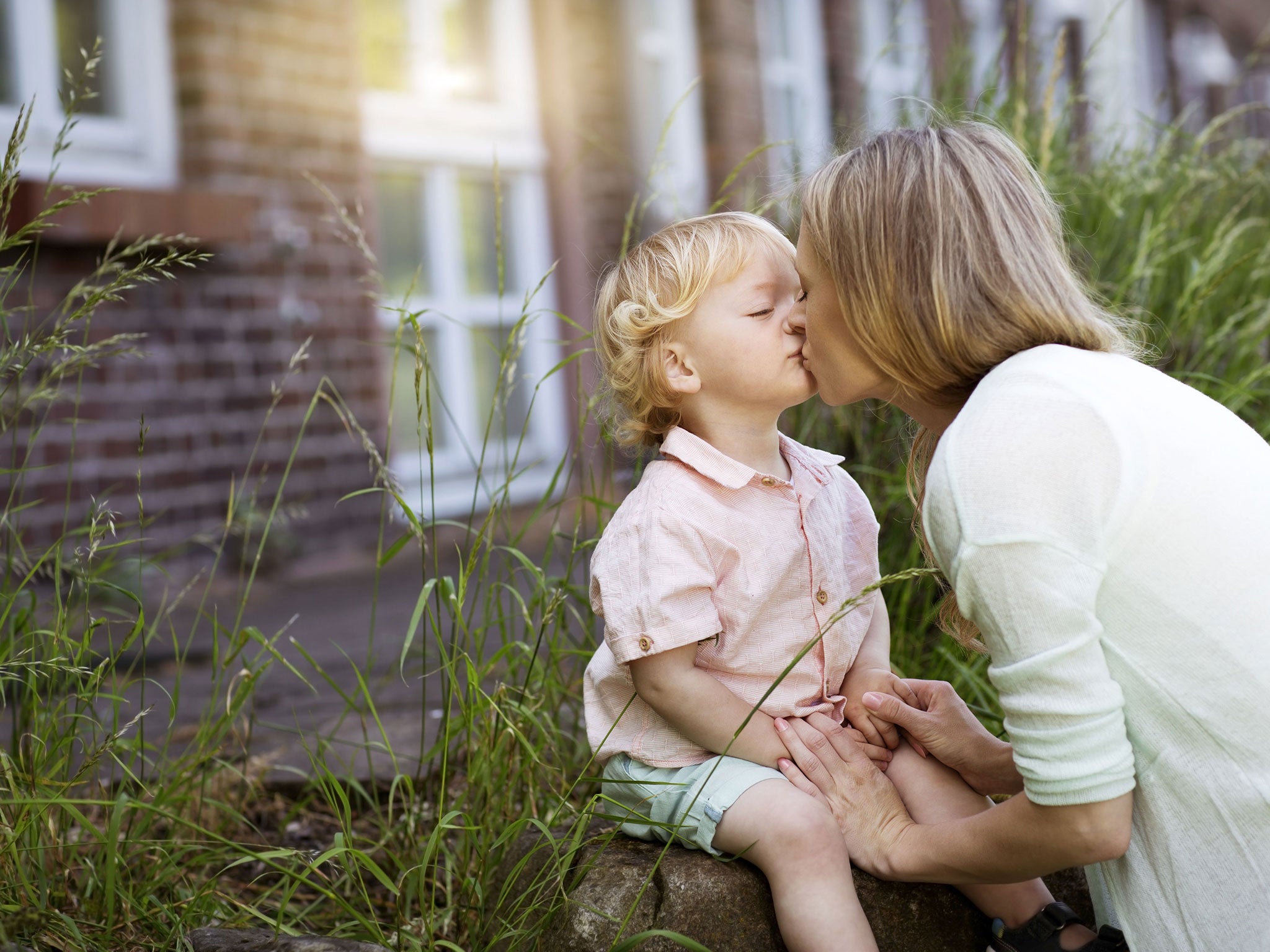 A mother kisses her son