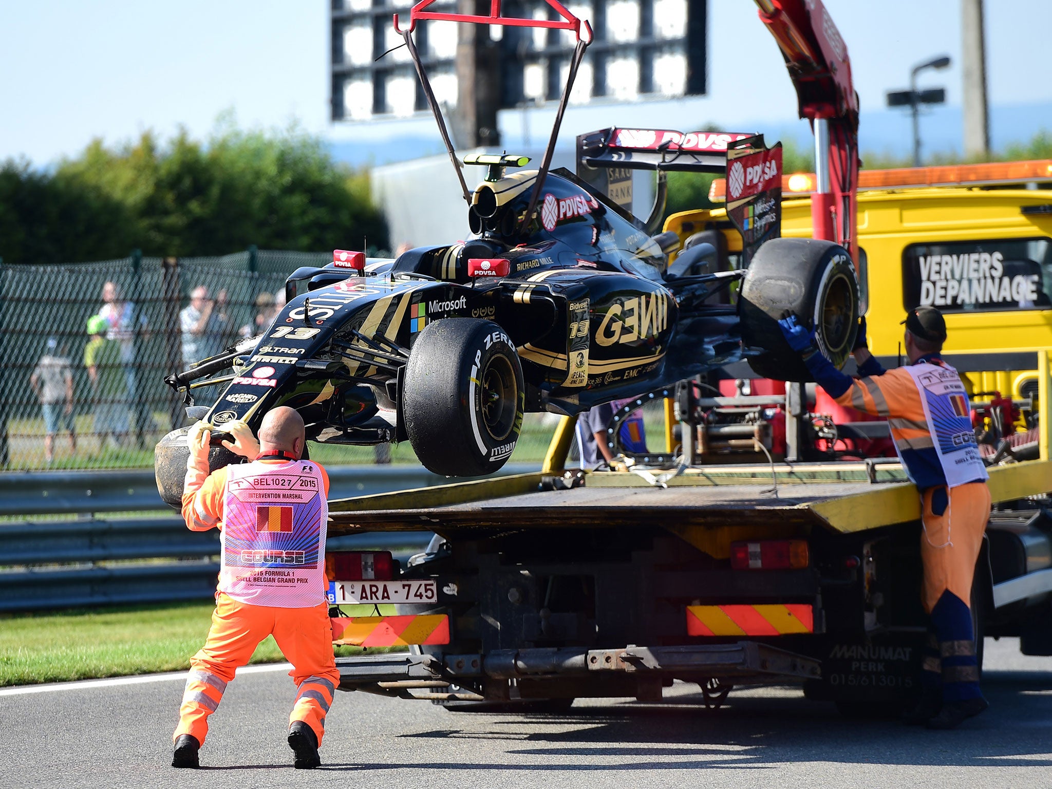 Maldonado's damaged Lotus is hoisted onto the back of a recovery lorry